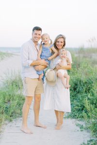 parents hold young girls during beach family photos