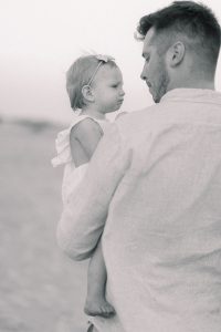 dad holds young daughter along beach in Charleston SC