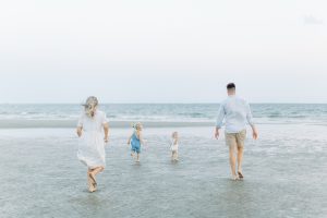 parents chase daughters in water during Charleston family photos