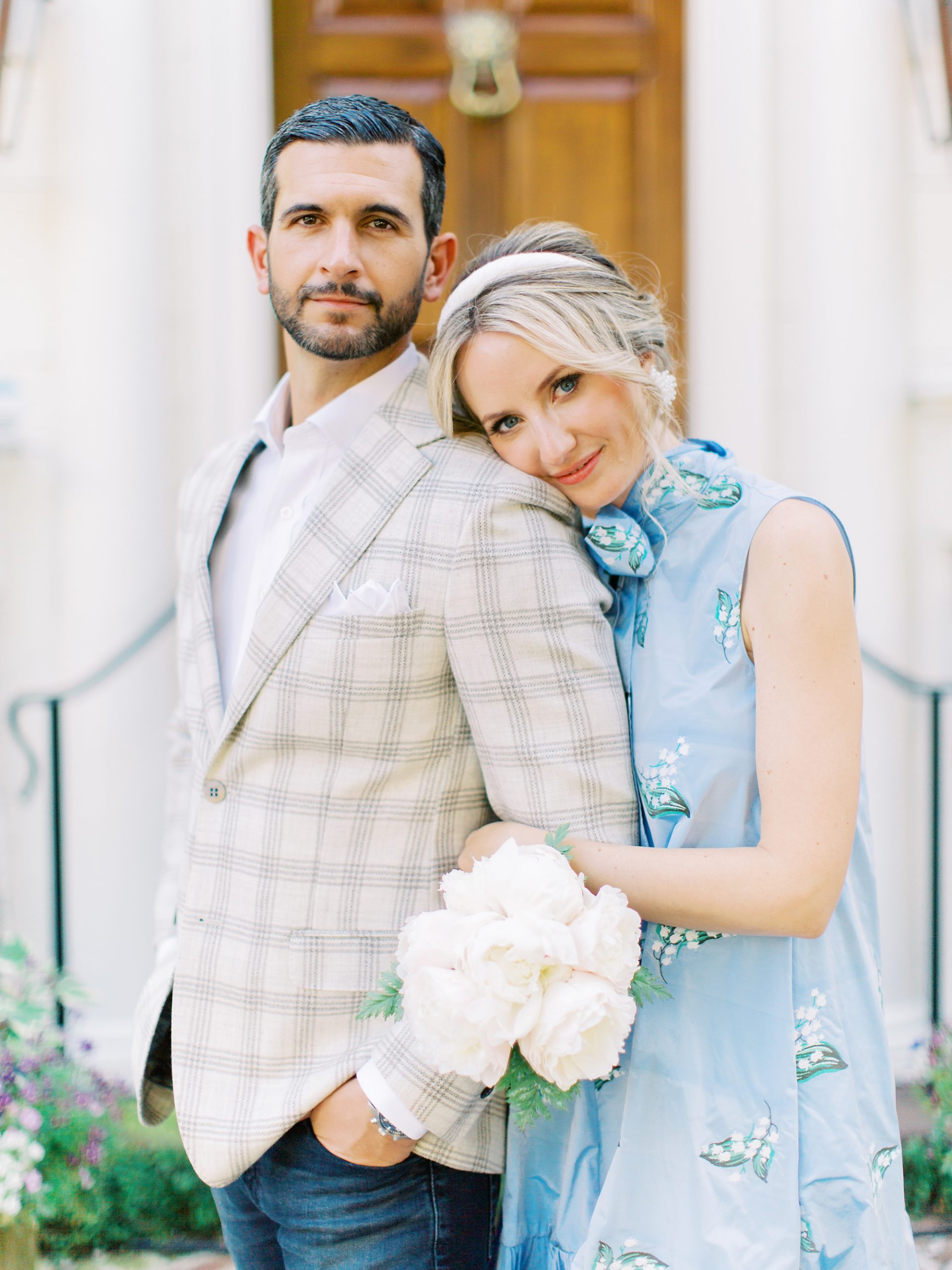 woman in blue dress leans on groom's shoulder