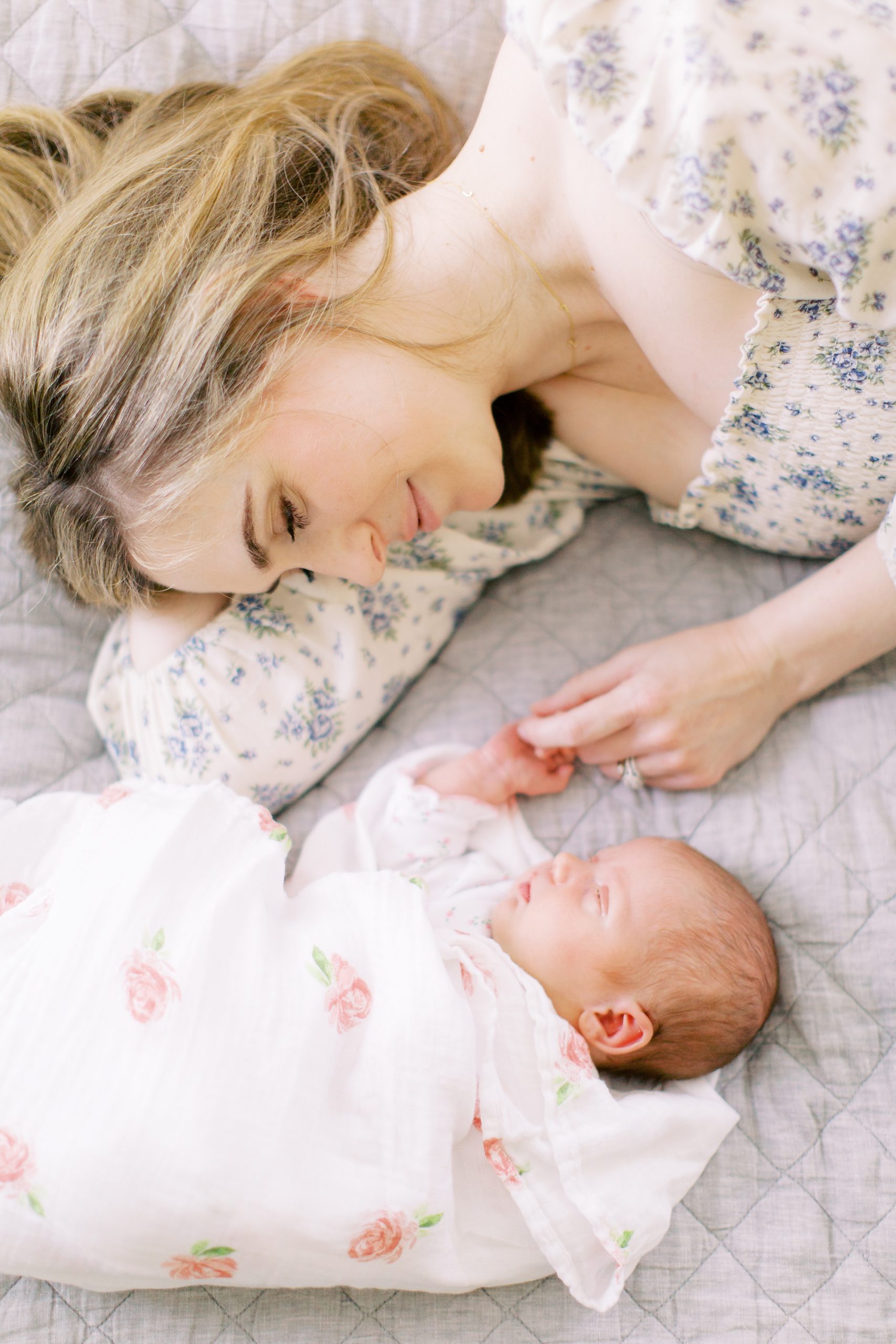 mom looks down at baby girl during In Home Lifestyle Newborn Session
