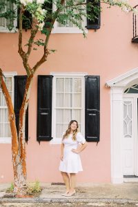 woman poses by peach house during Charleston branding session