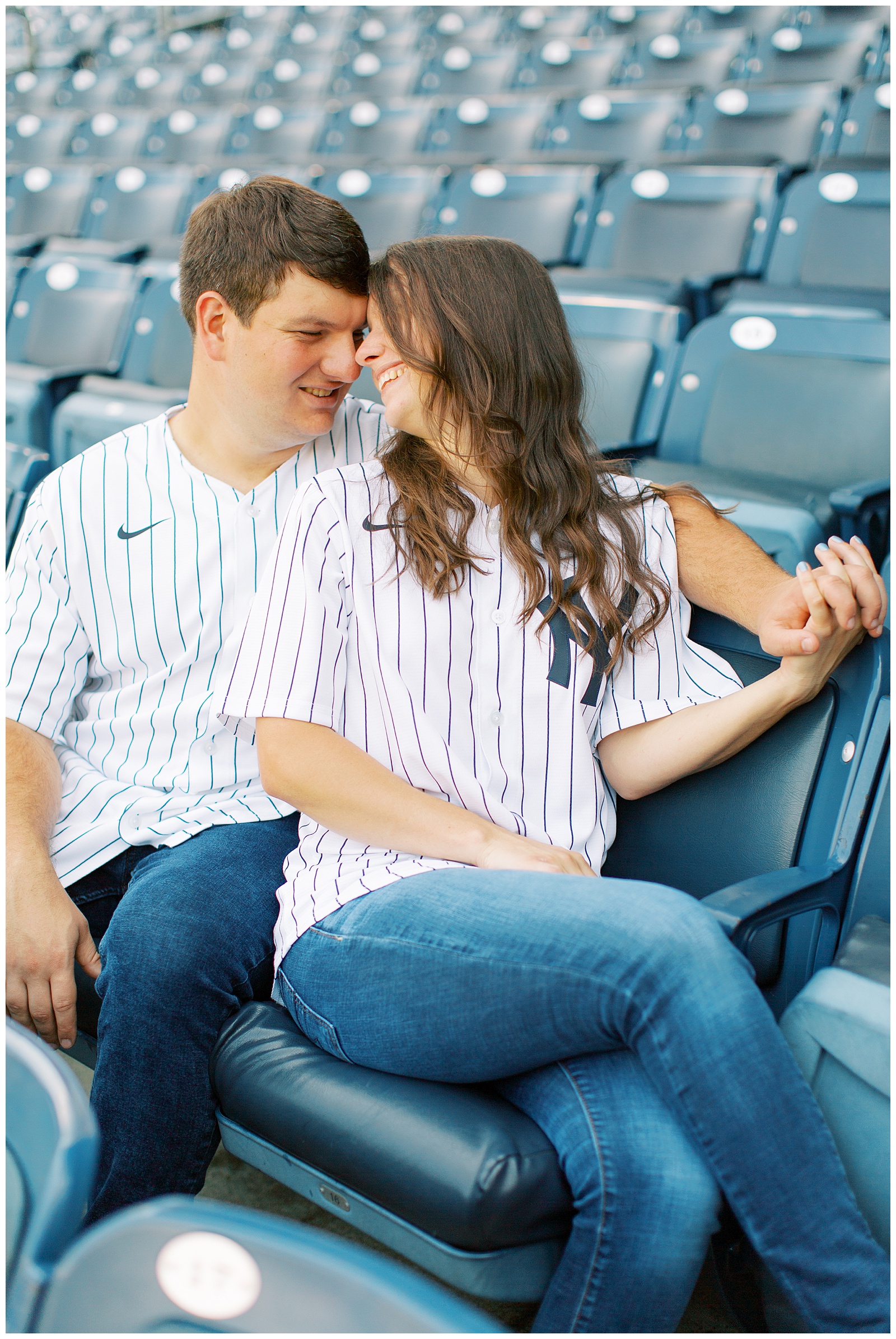 bride and groom sit in seats at Monument Park during Yankee Stadium Engagement Session