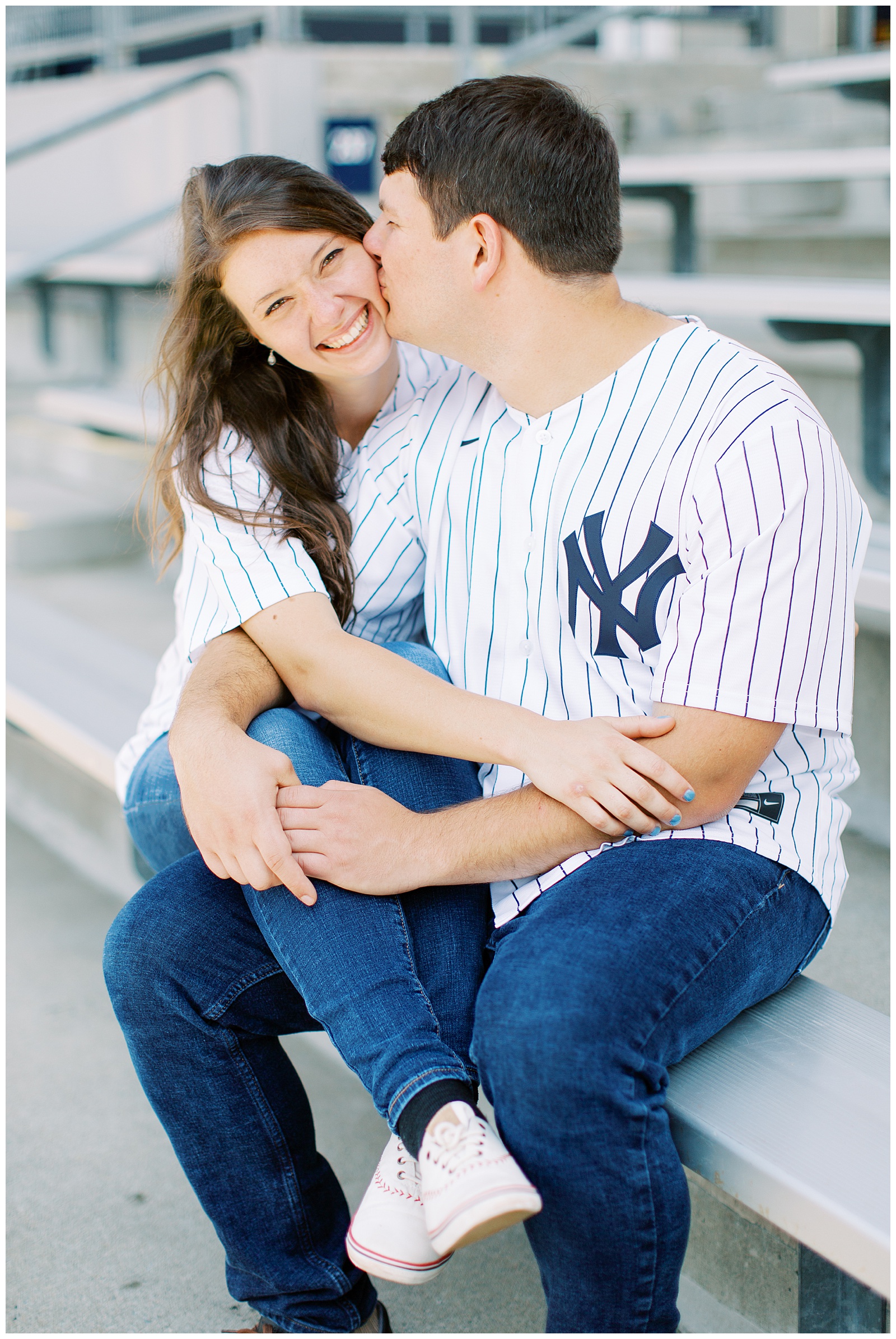 bride and groom sit on bench during engagement session at Monument Park 