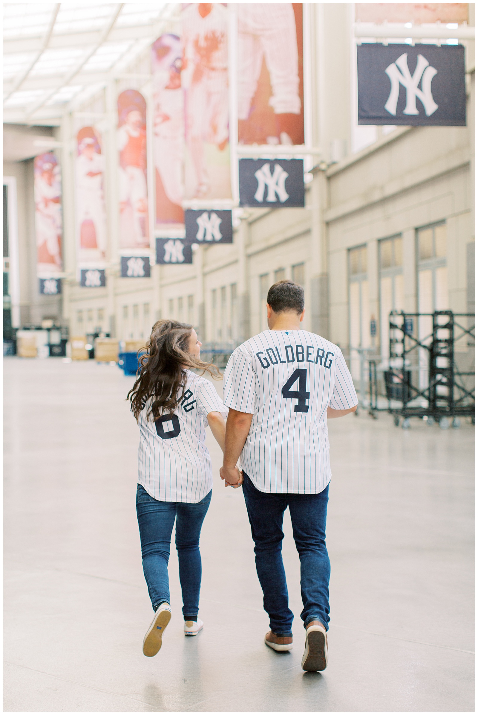 engaged couple holds hands walking during Yankee Stadium Engagement Session