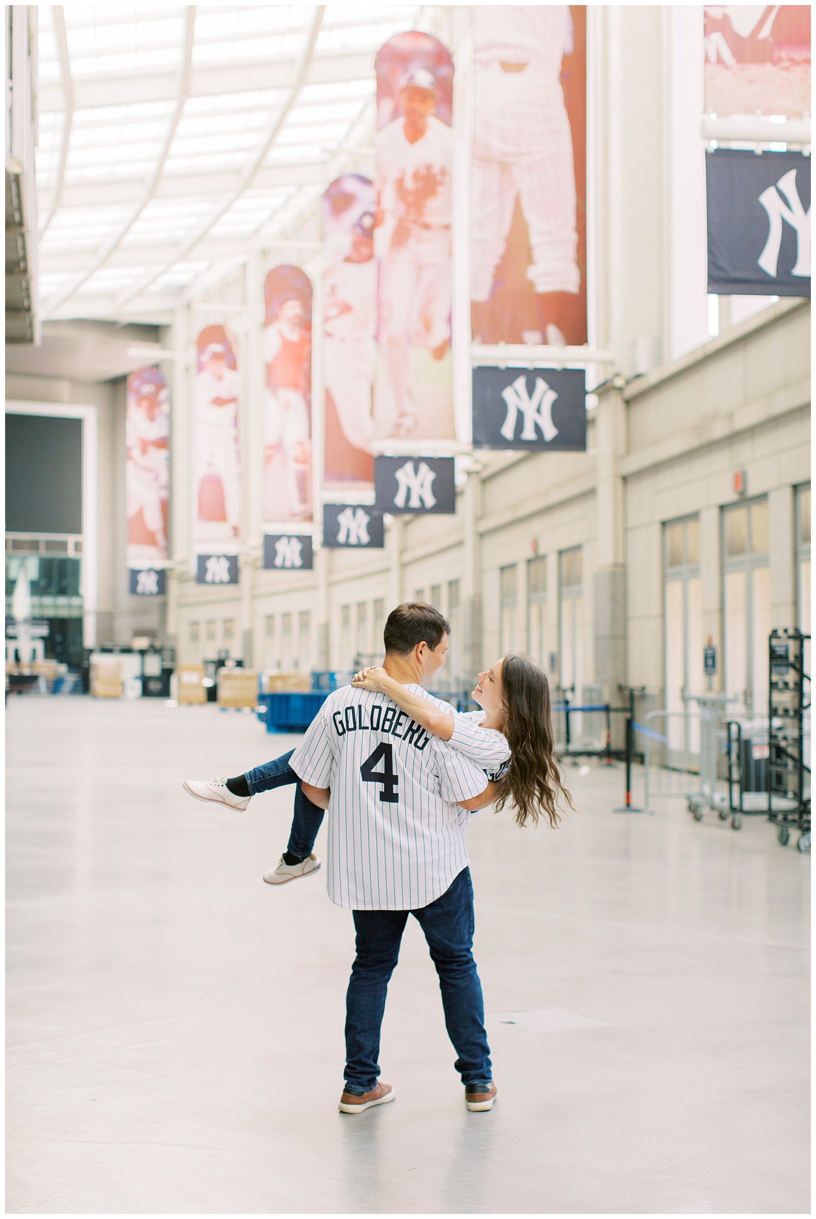 groom carries bride through Yankee Stadium for engagement photos 