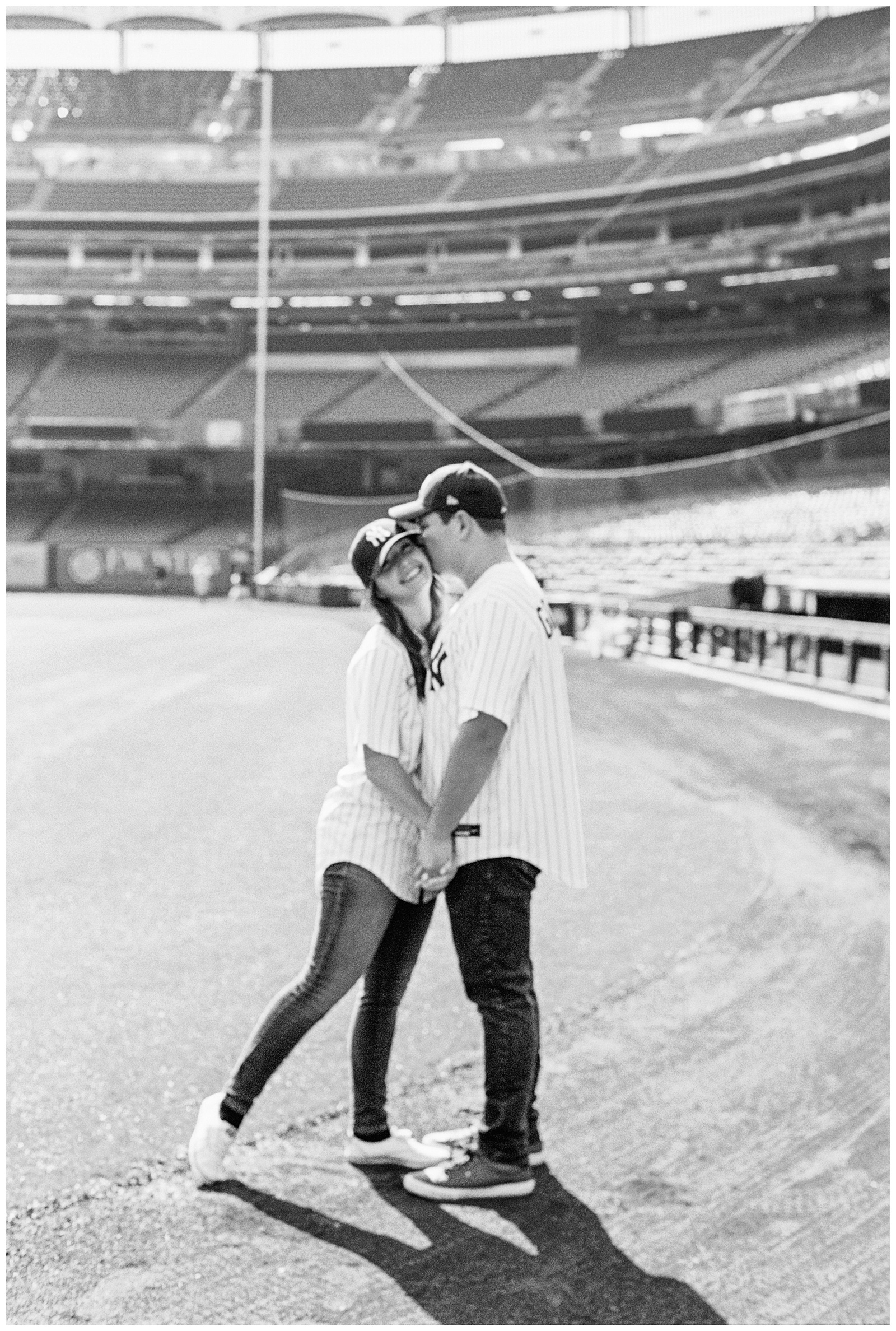 couple stands together on field during Yankee Stadium Engagement Session