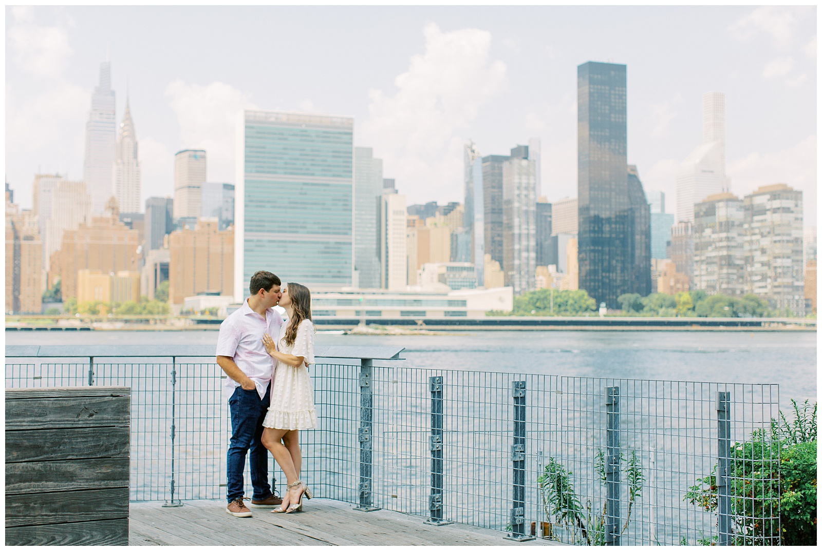 engaged couple poses in front of Manhattan skyline 