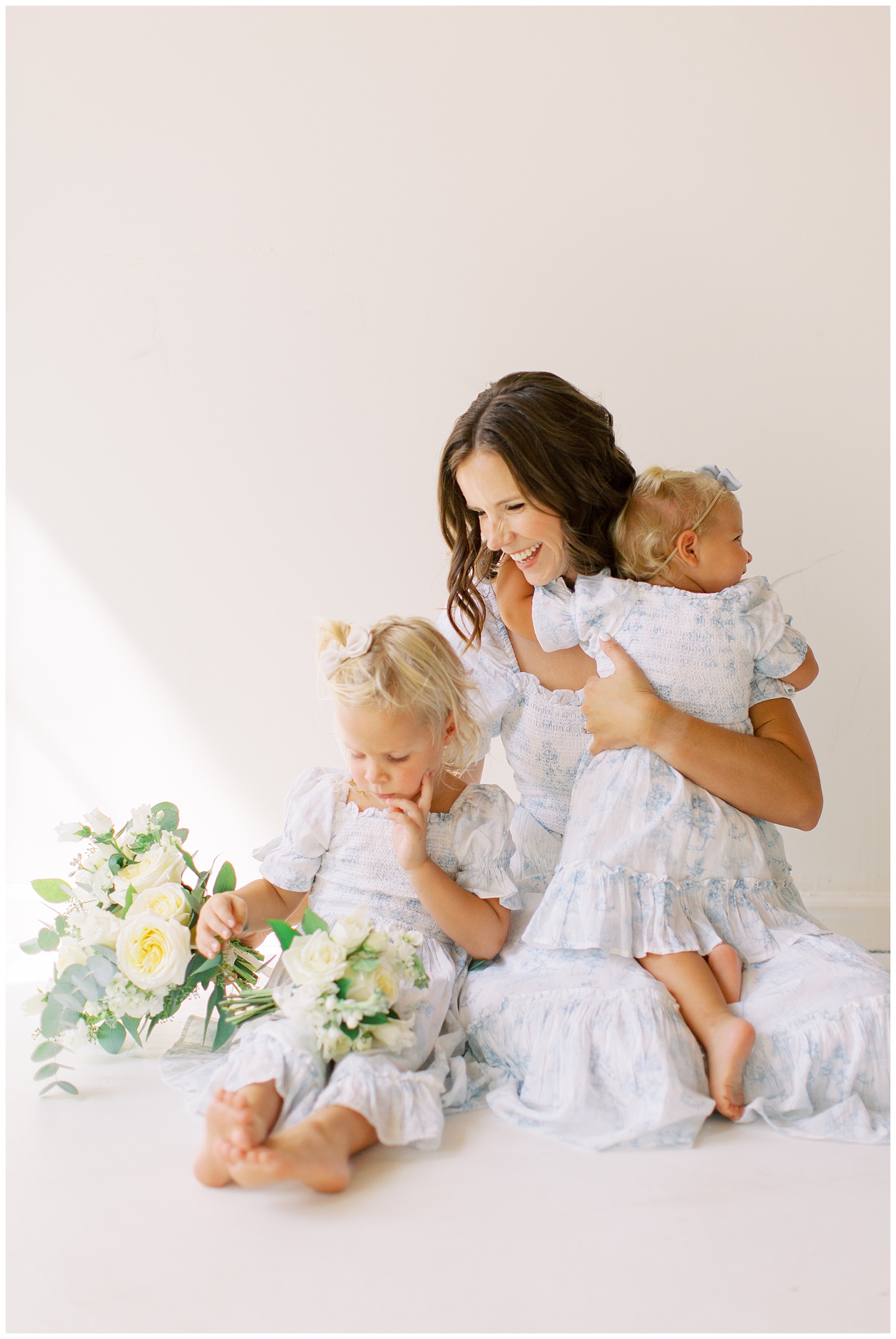 mom hugs two daughters in matching dresses during branding photos