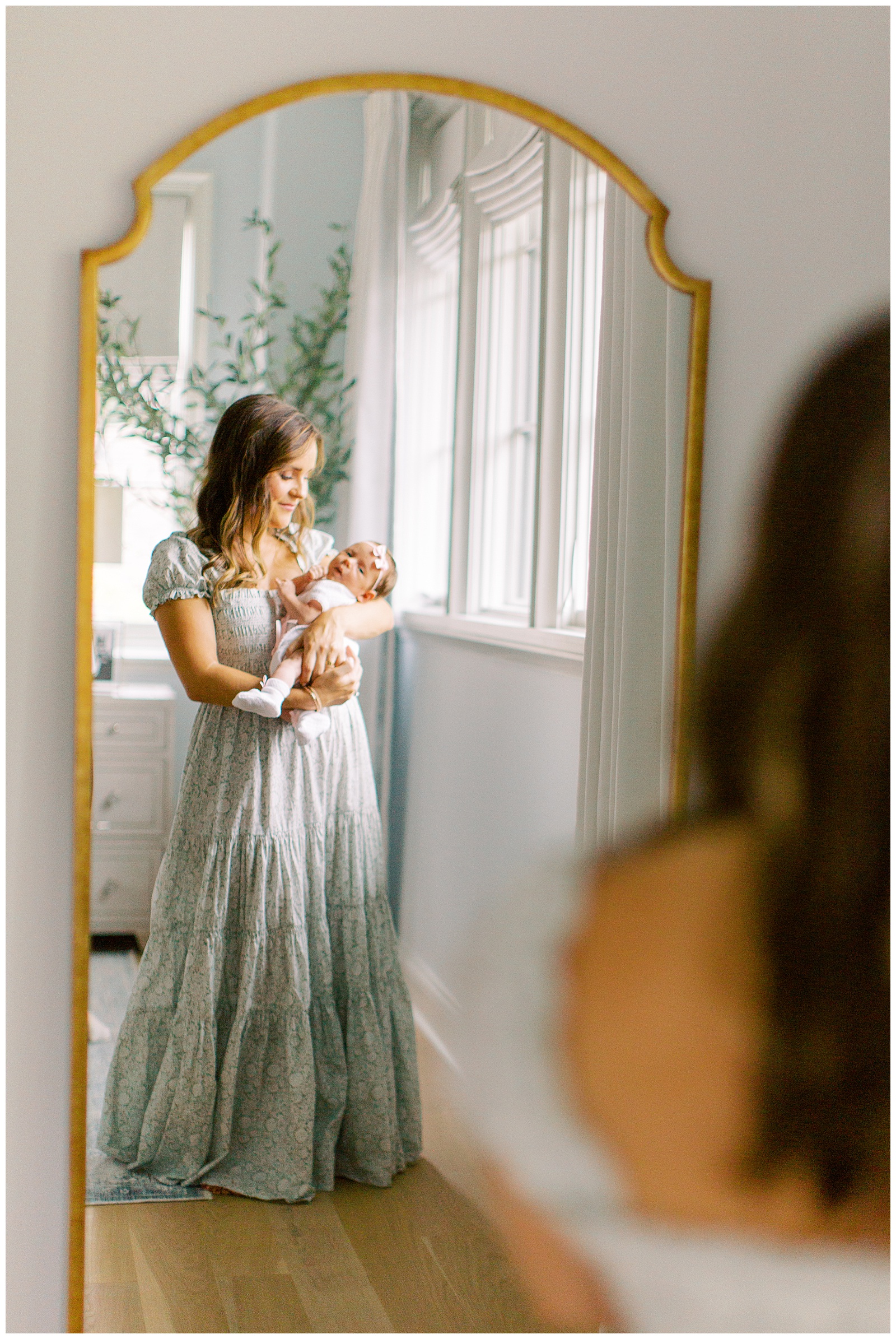 mom holds daughter looking in mirror during Lifestyle Newborn Session in Charlotte