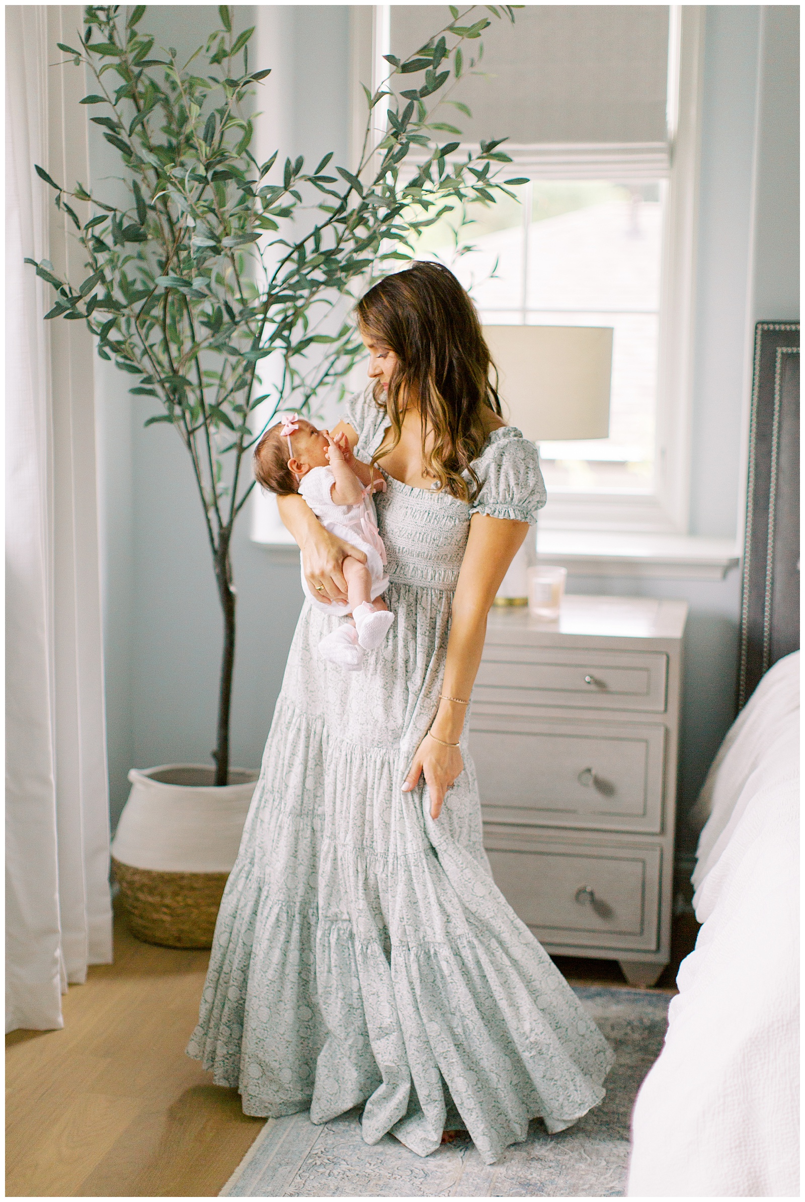 mom holds daughter and twirls dress during Lifestyle Newborn Session in Charlotte