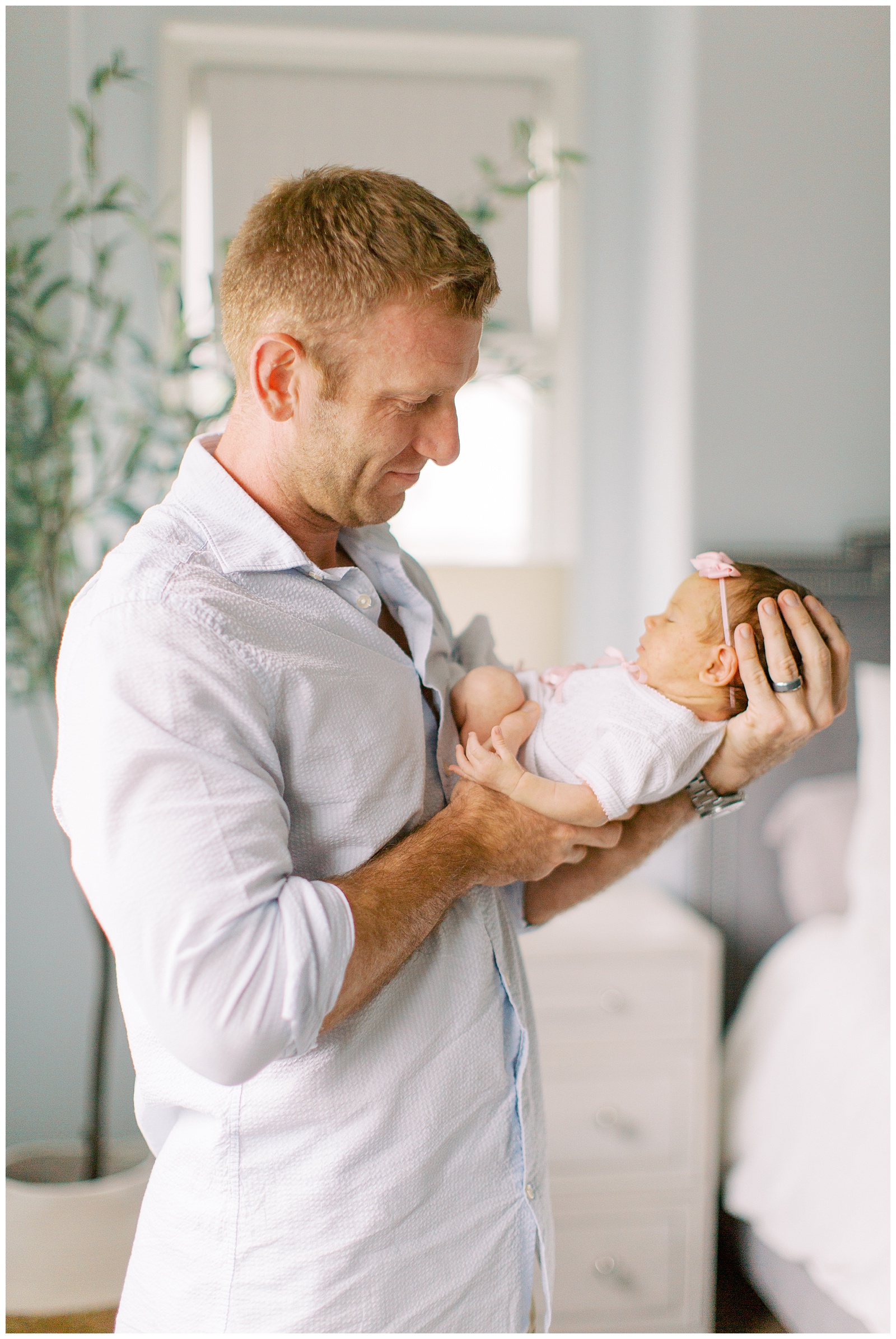 dad looks at daughter during Lifestyle Newborn Session in Charlotte