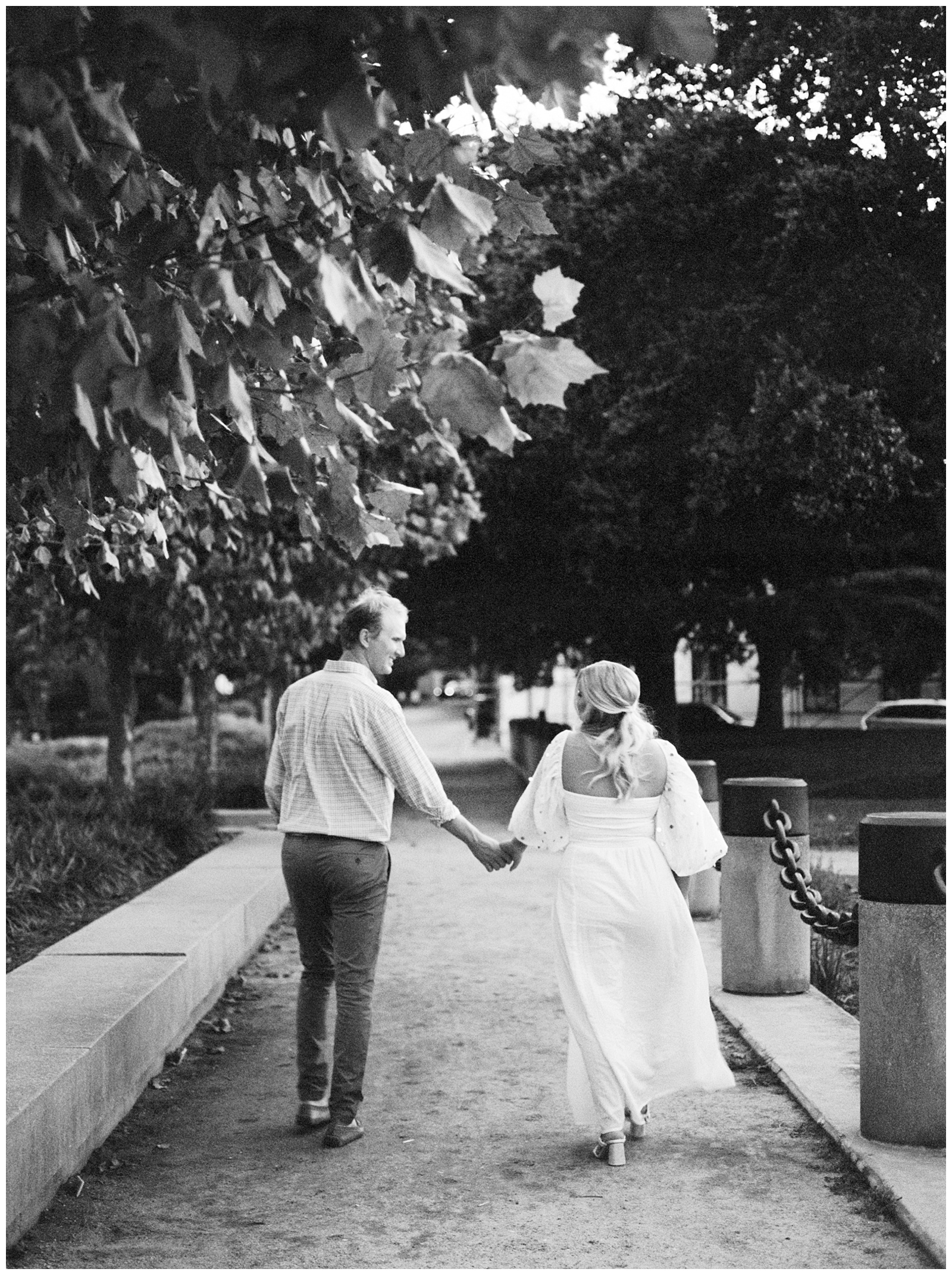black and white portraits f bride and groom walking through Hampton Park