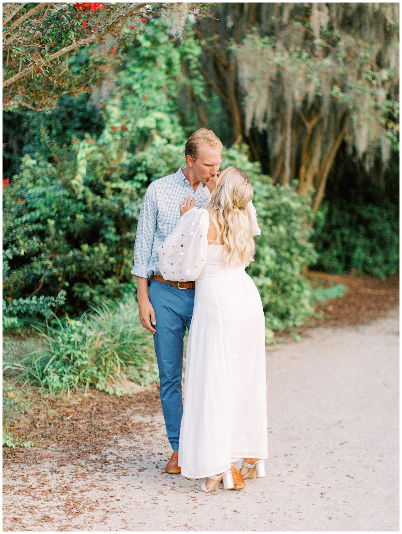 bride and groom kiss on pathway in Hampton Park during downtown Charleston engagement session