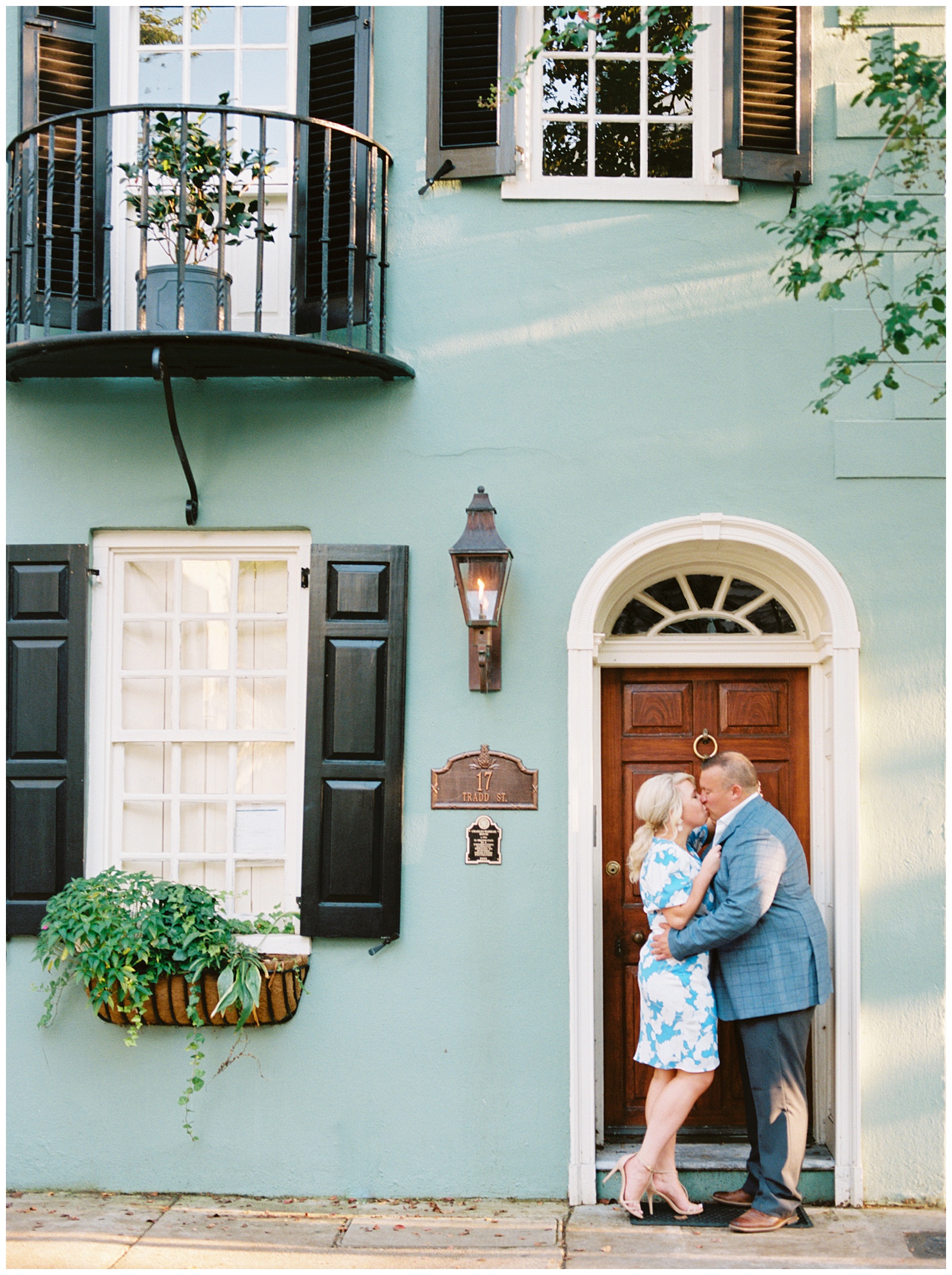bride and groom kiss on doorstep of historic home during Downtown Charleston engagement session
