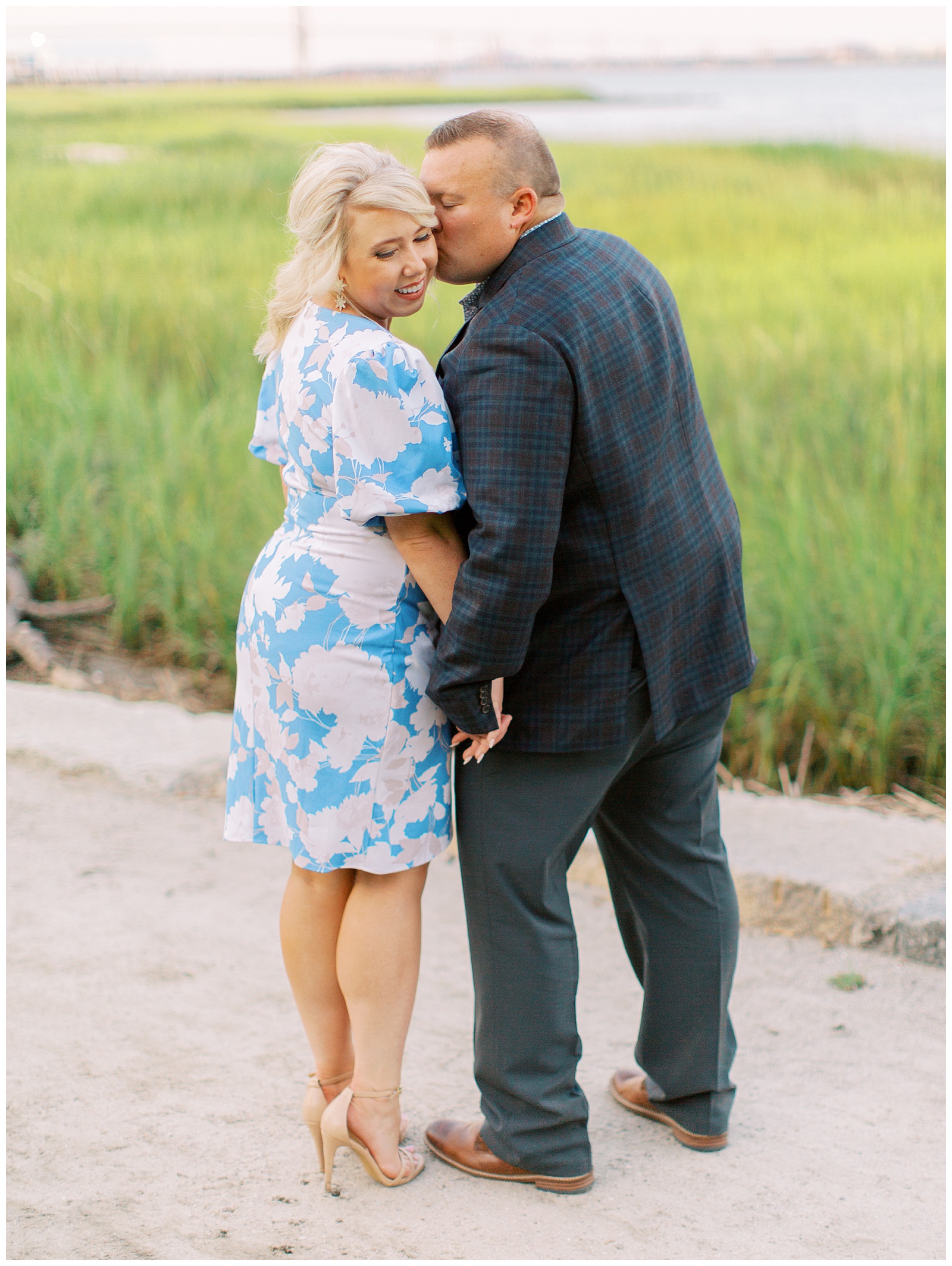 groom kisses bride's cheek during Downtown Charleston engagement session