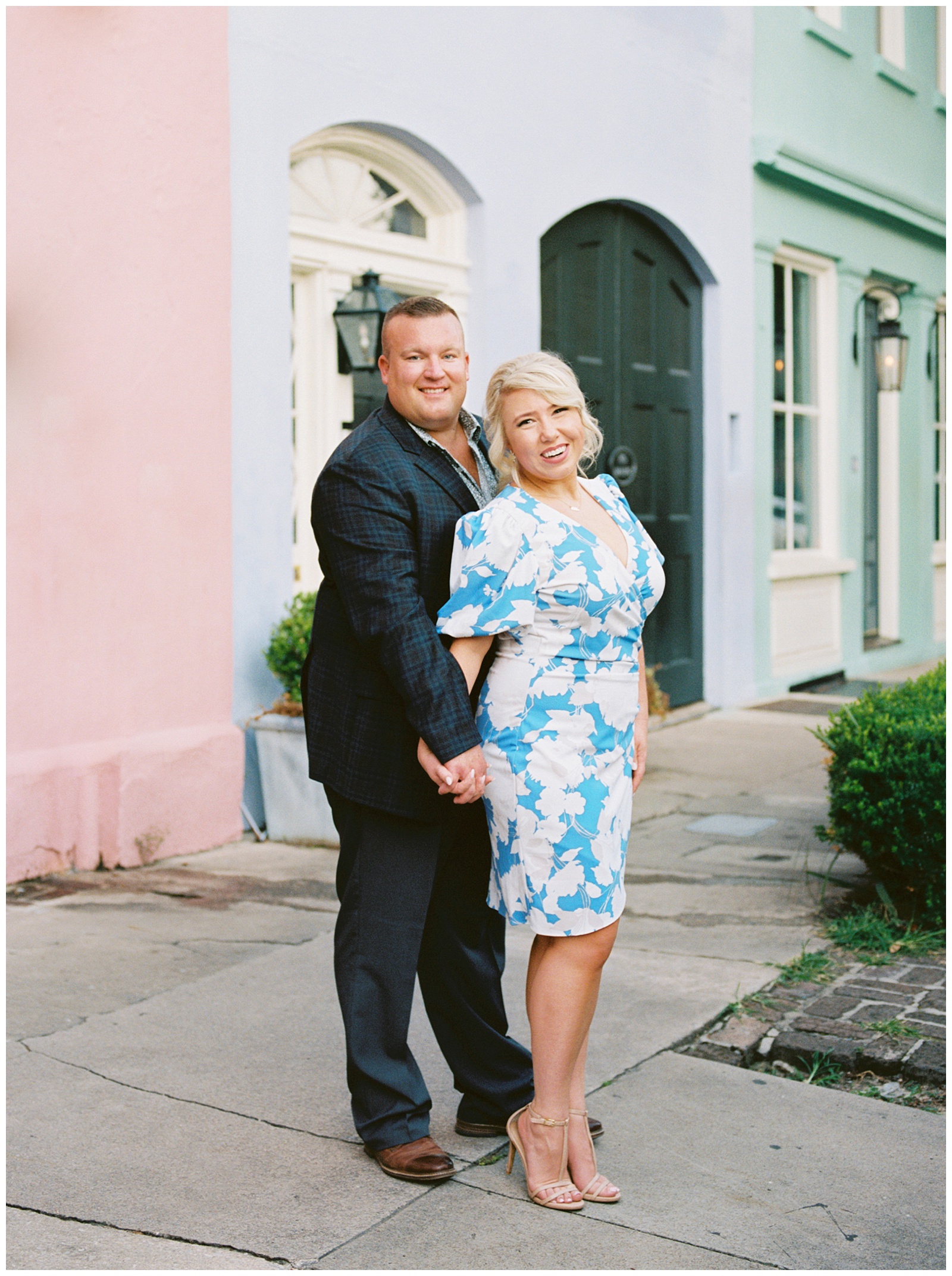 engaged couple poses on rainbow row during Downtown Charleston engagement session