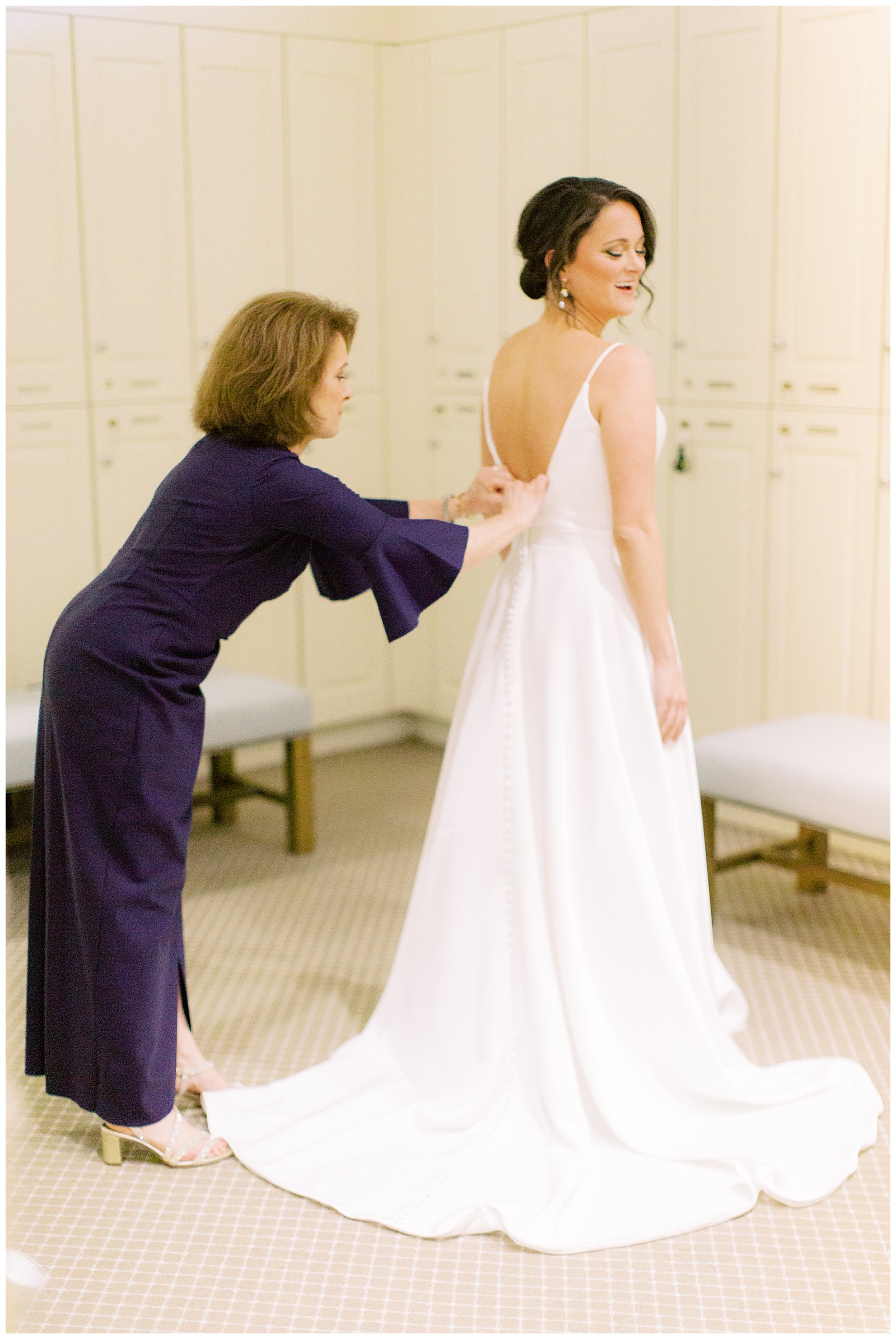 mother helps bride with wedding dress before Charlotte NC ceremony