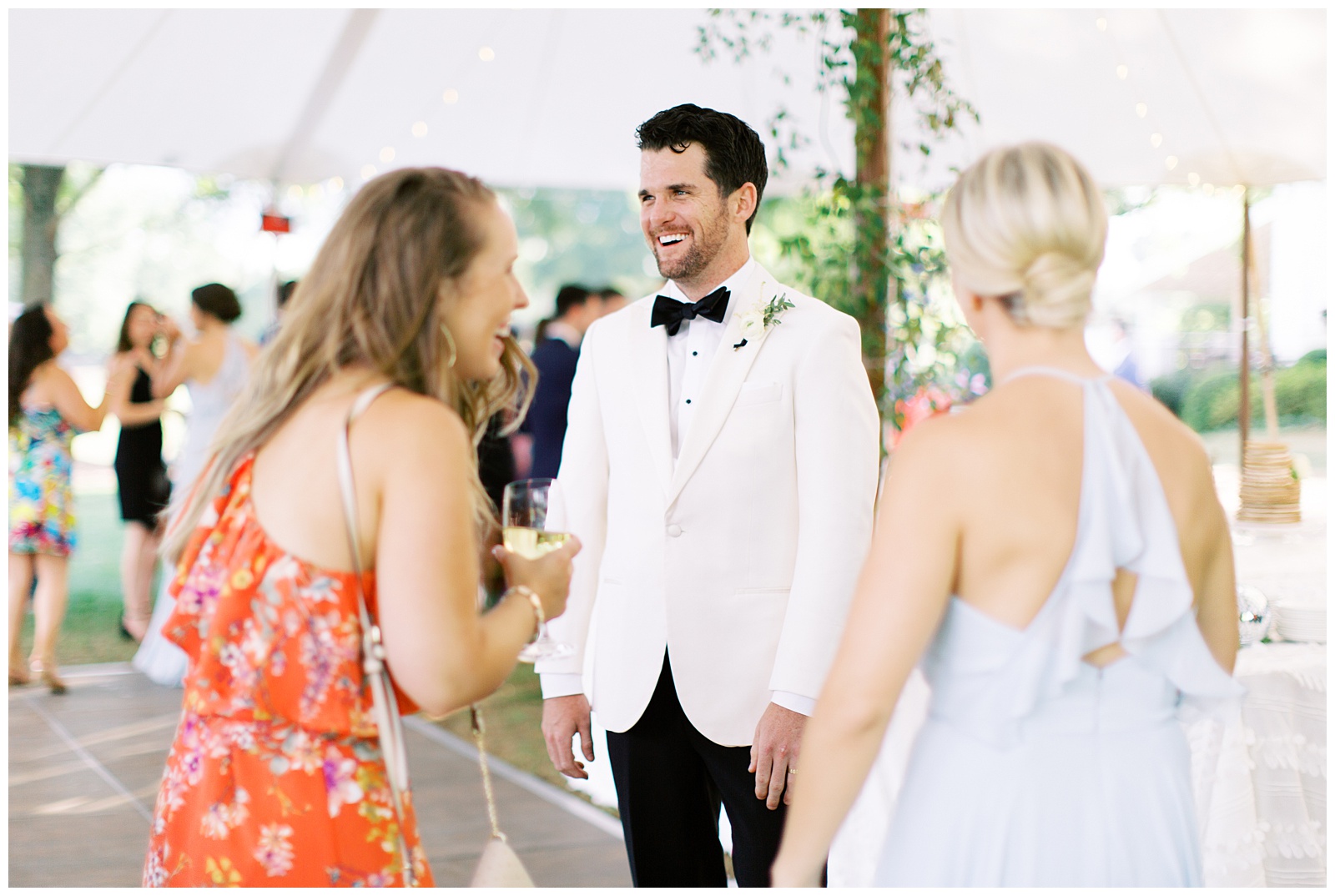 groom laughs with wedding guests during Quail Hollow Country Club wedding