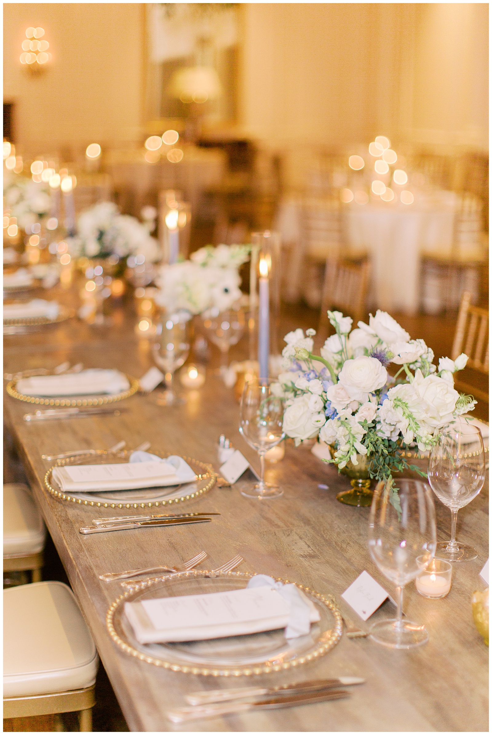 wedding reception with gold plates and blue taper candles at Quail Hollow Country Club