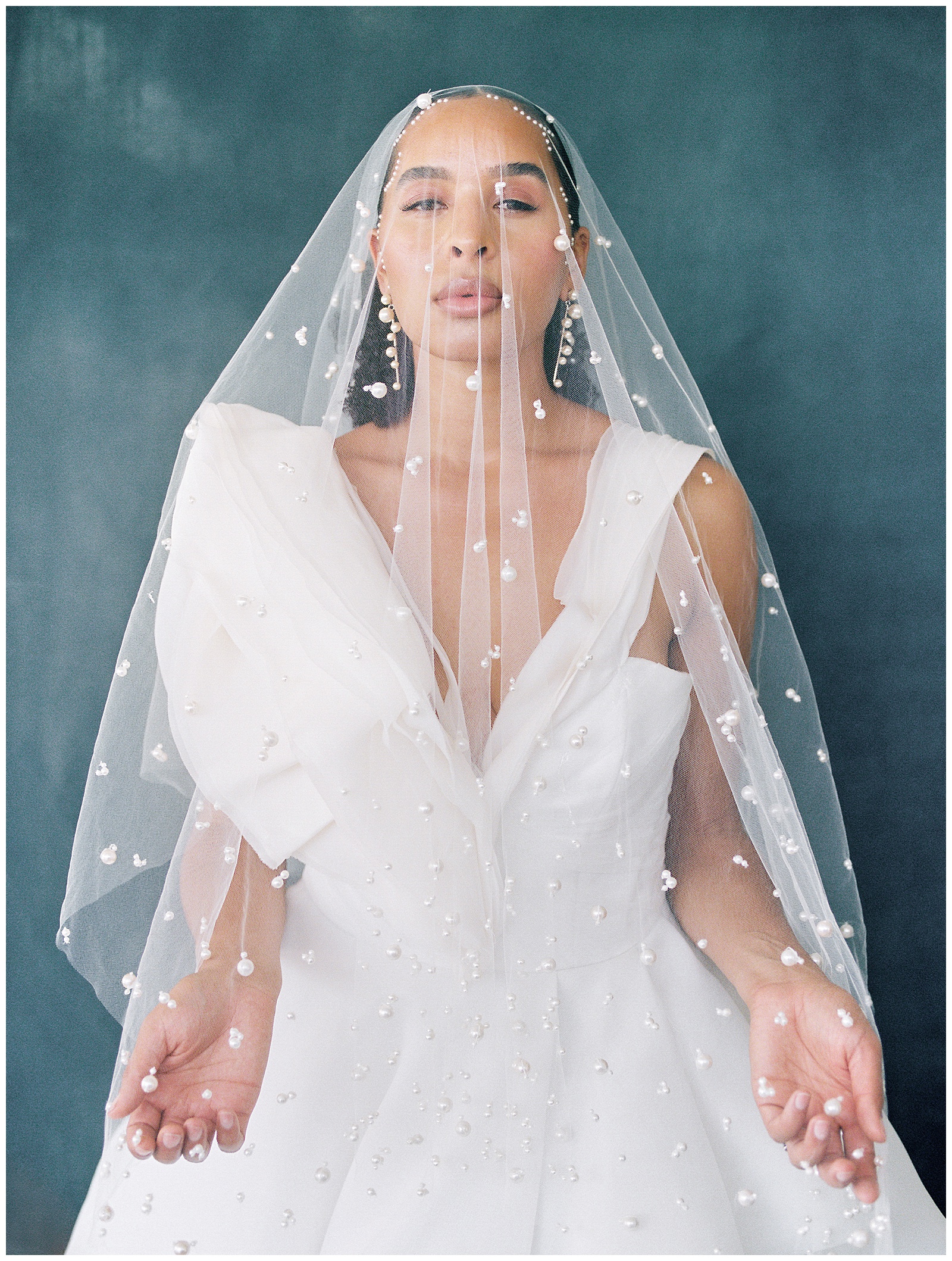 bride poses under veil dotted with pearls for River Bottoms Ranch Wedding styled shoot