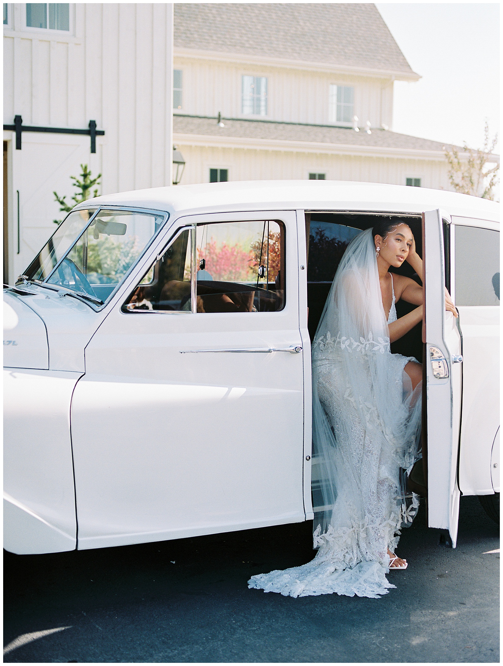 bride sits in white Rolls Royce leaning out of window