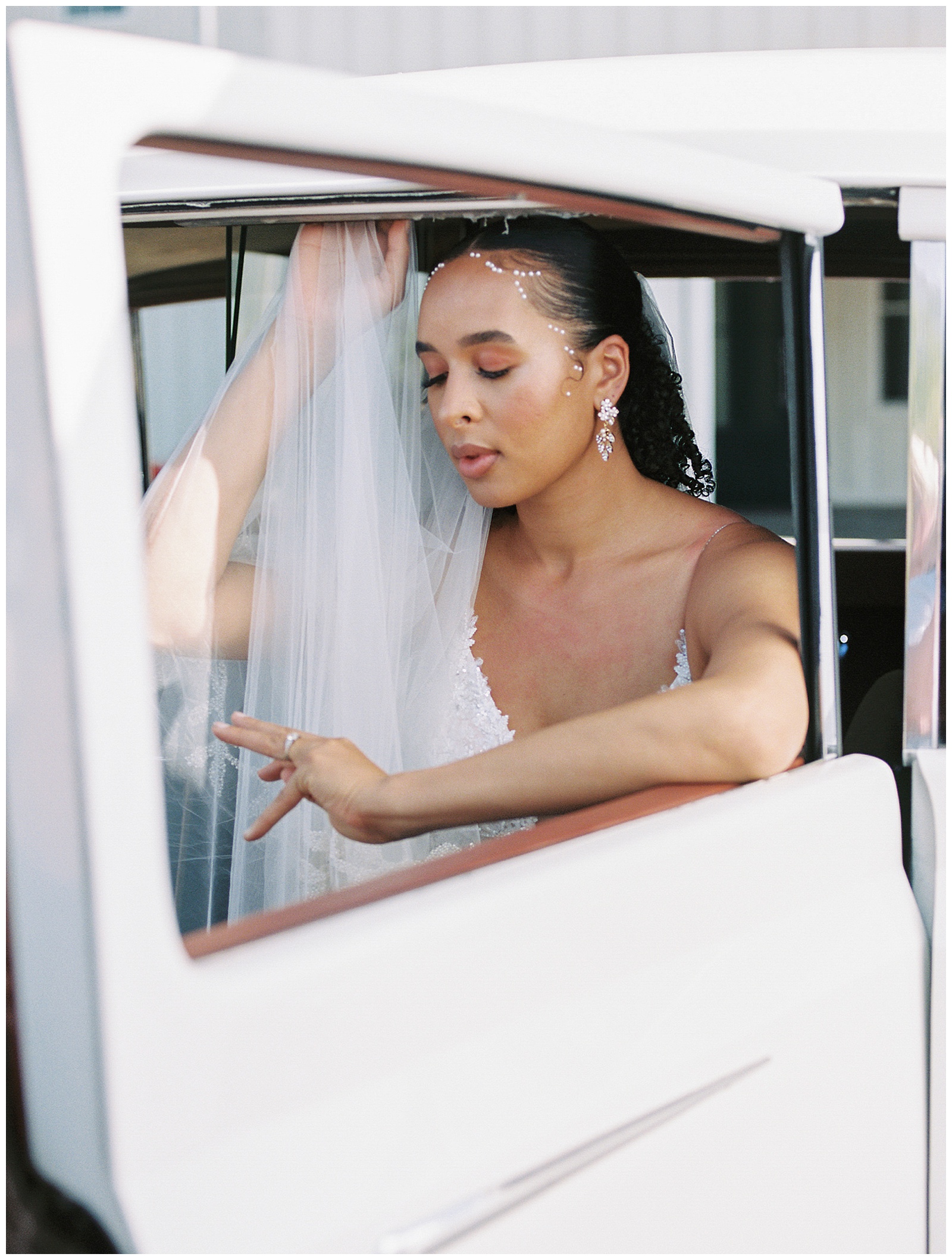 bride leans against window of Rolls Royce outside River Bottoms Ranch