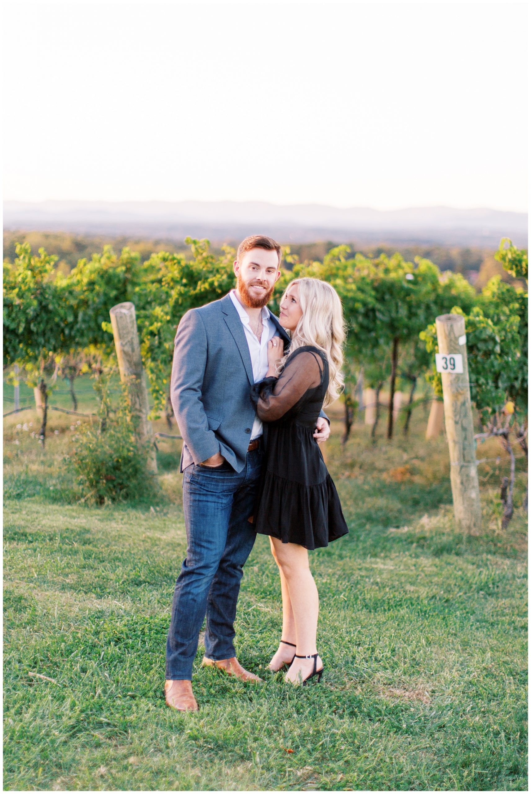 bride looks up at groom leaning on his arm during Raffaldini Vineyards engagement session 