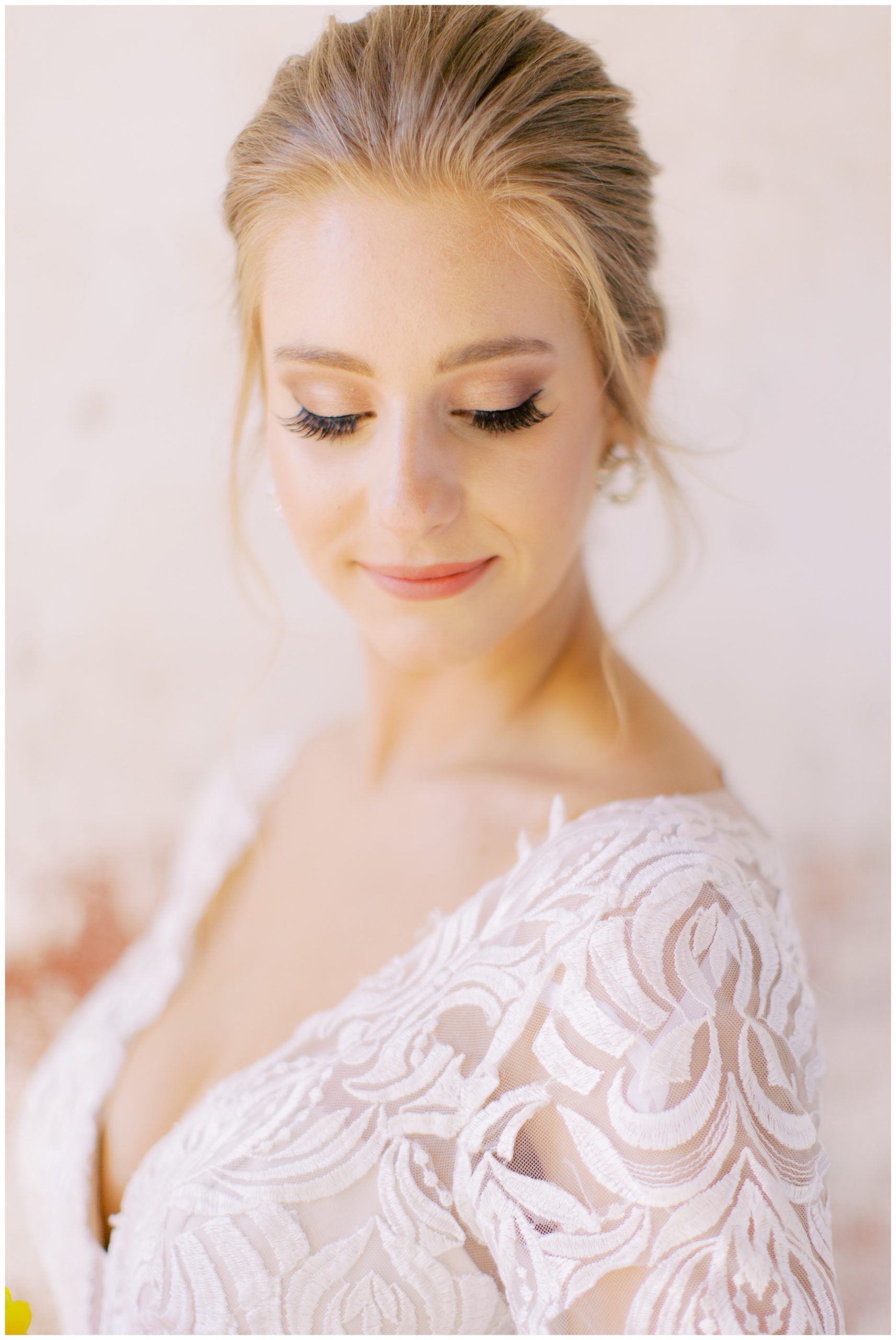 bride looks down over shoulder in lace sleeve of wedding gown