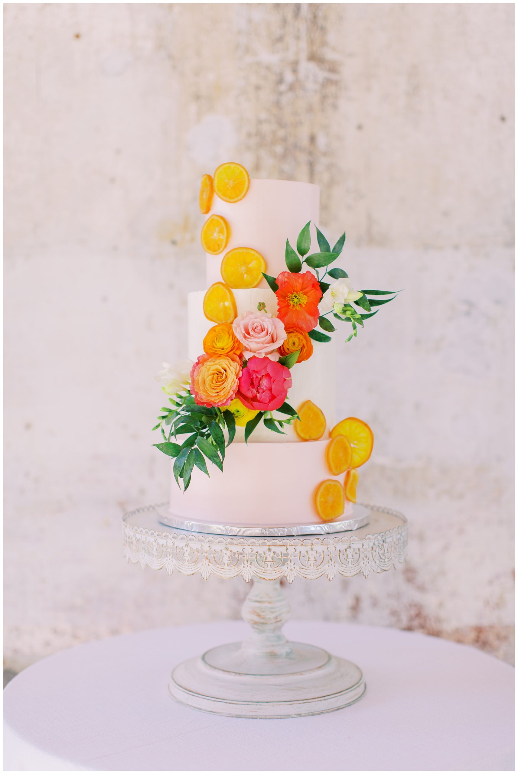 tiered wedding cake with citrus slices wrapping down for citrus inspired wedding