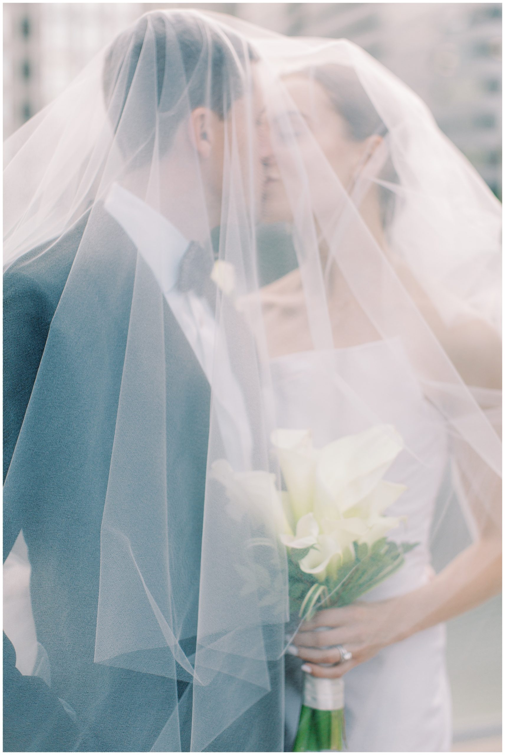 bride and groom kiss under veil during Charlotte wedding portraits 