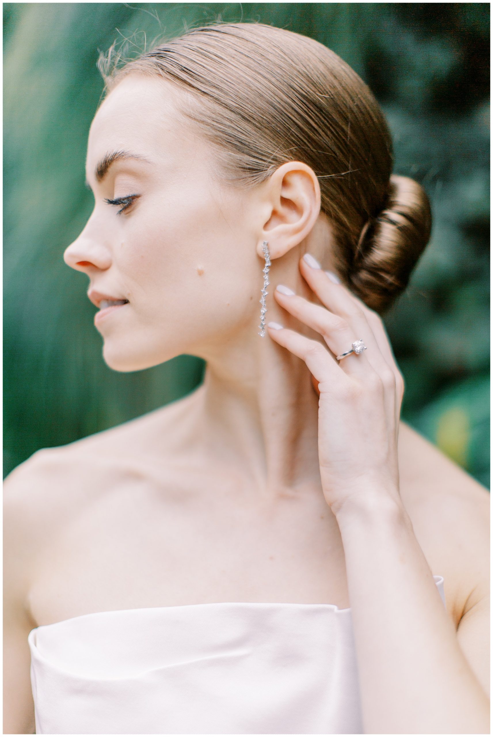 bride shows off diamond ring and drop earrings