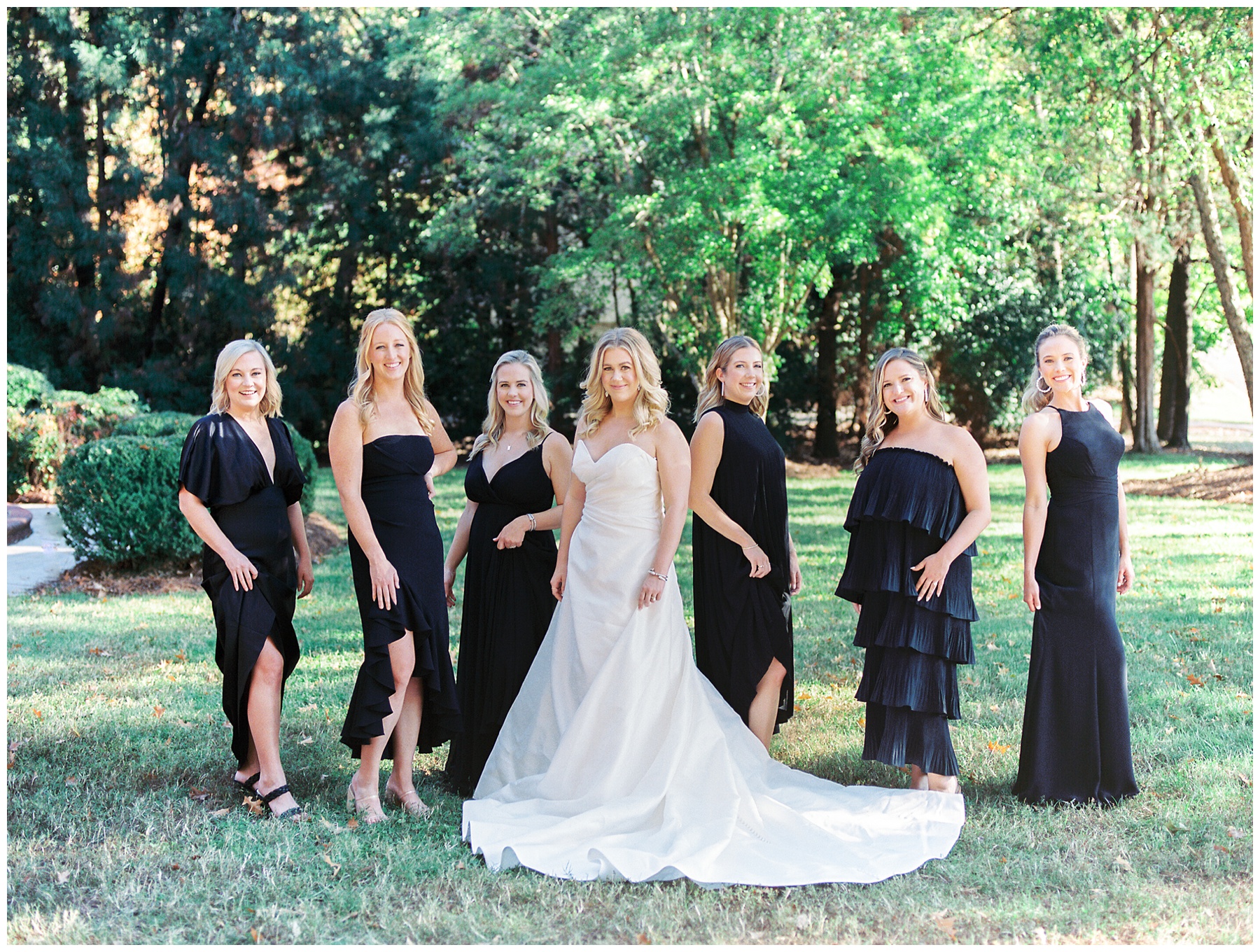 bride stands with bridesmaids in all-black dresses at The Terrace at Cedar Hill