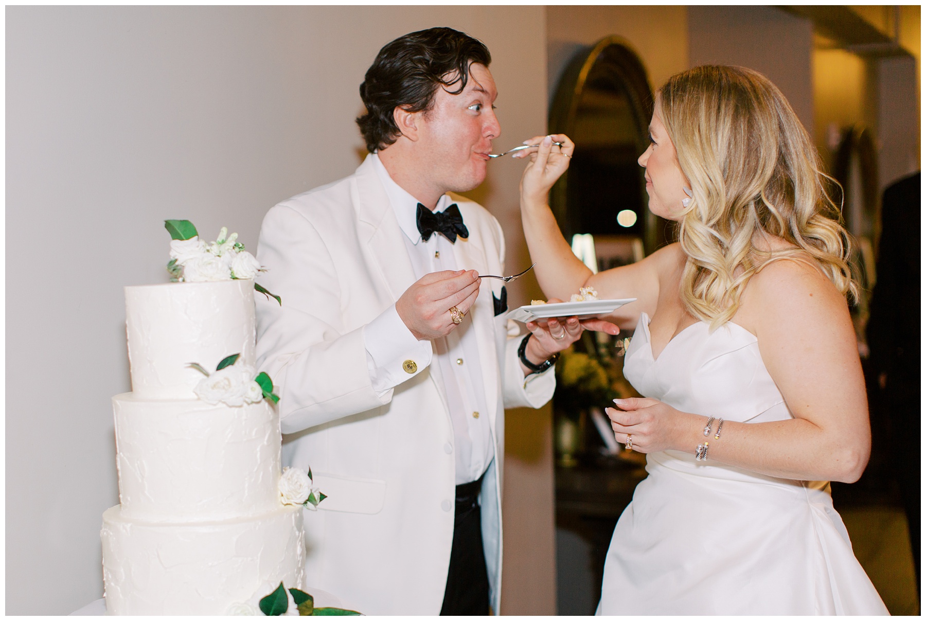 bride feeds groom cake during reception in Charlotte NC 