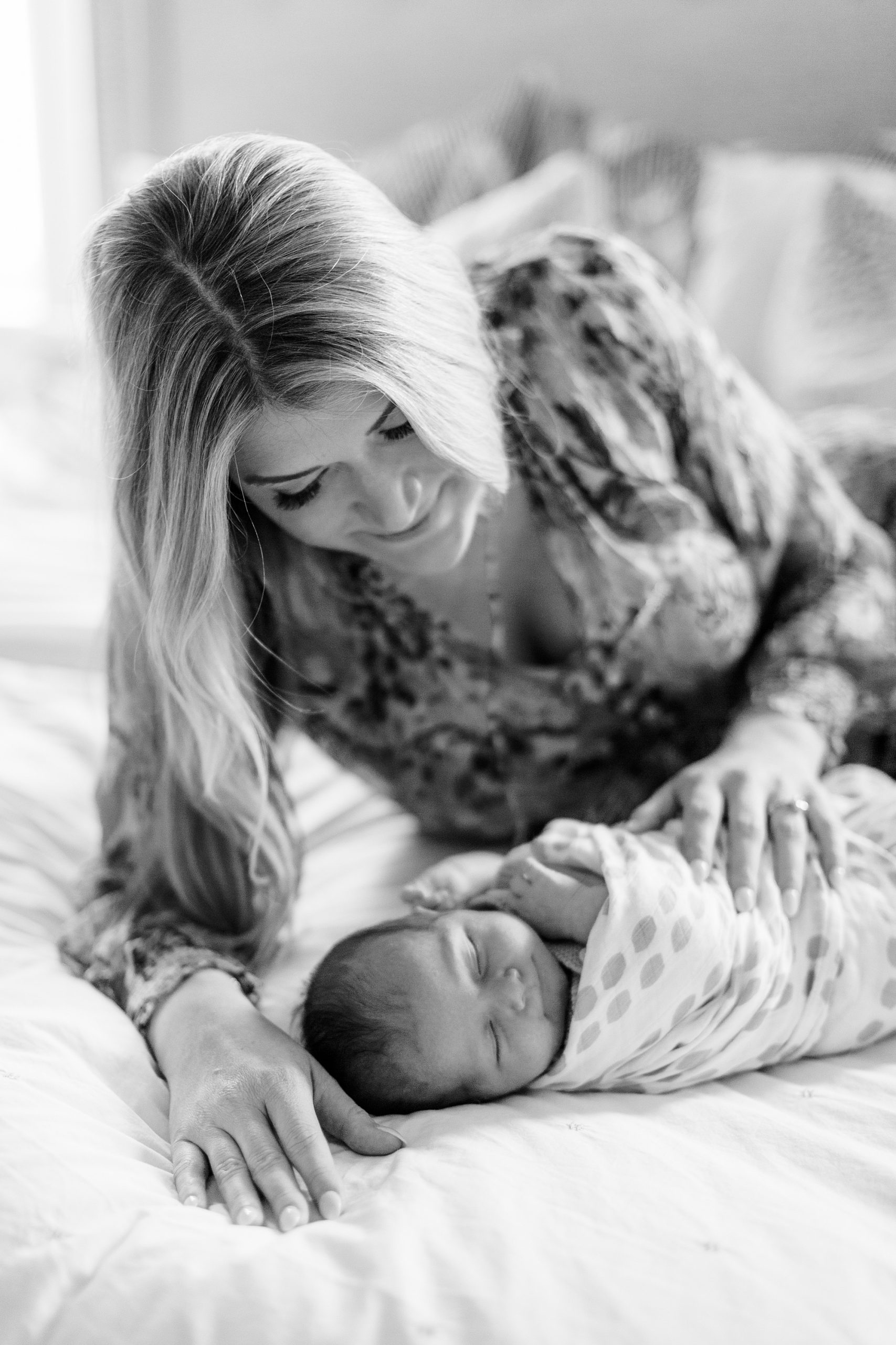 mom looks down at baby girl during Charlotte newborn session