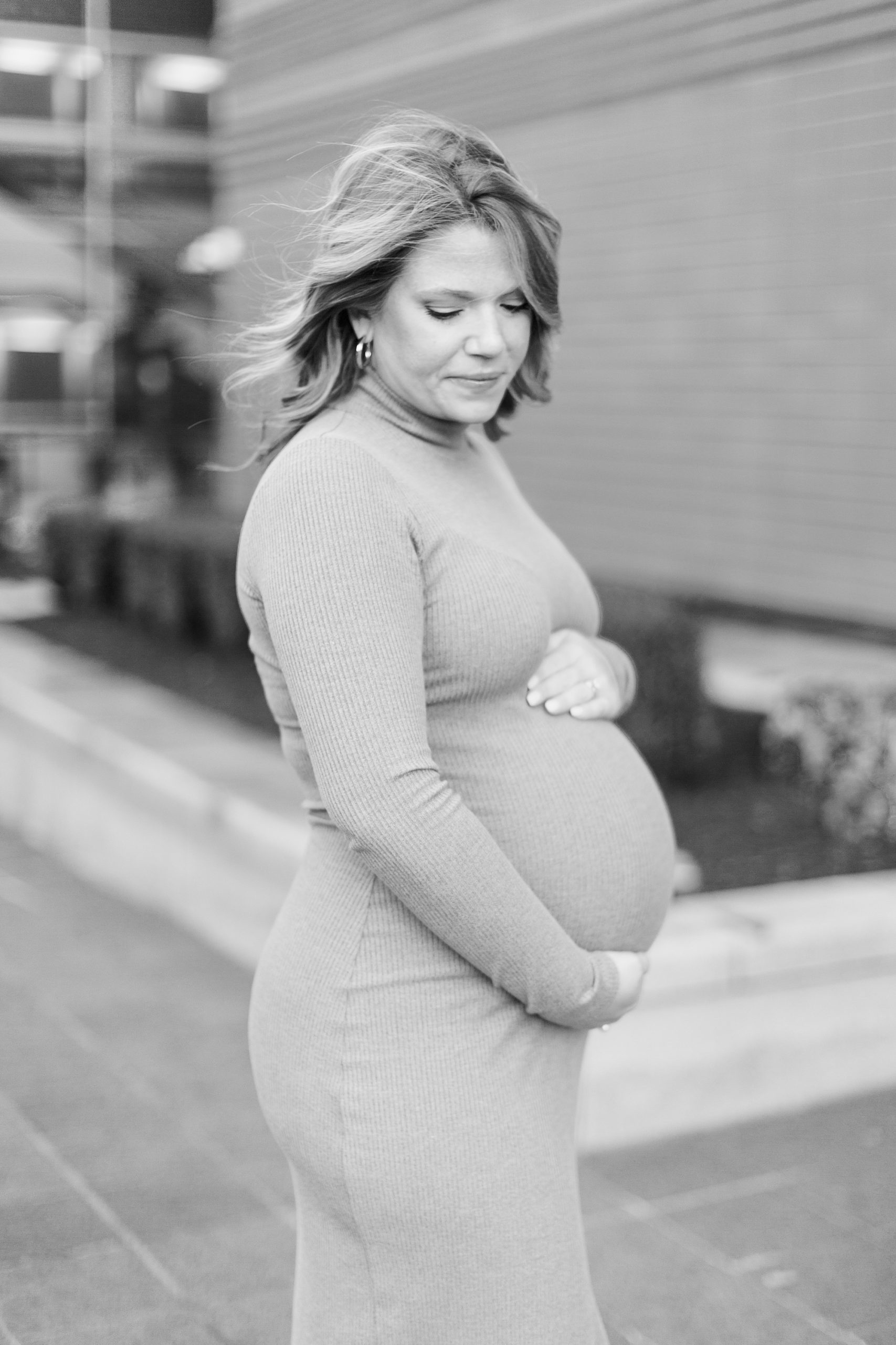 woman holds belly during Uptown Charlotte maternity session