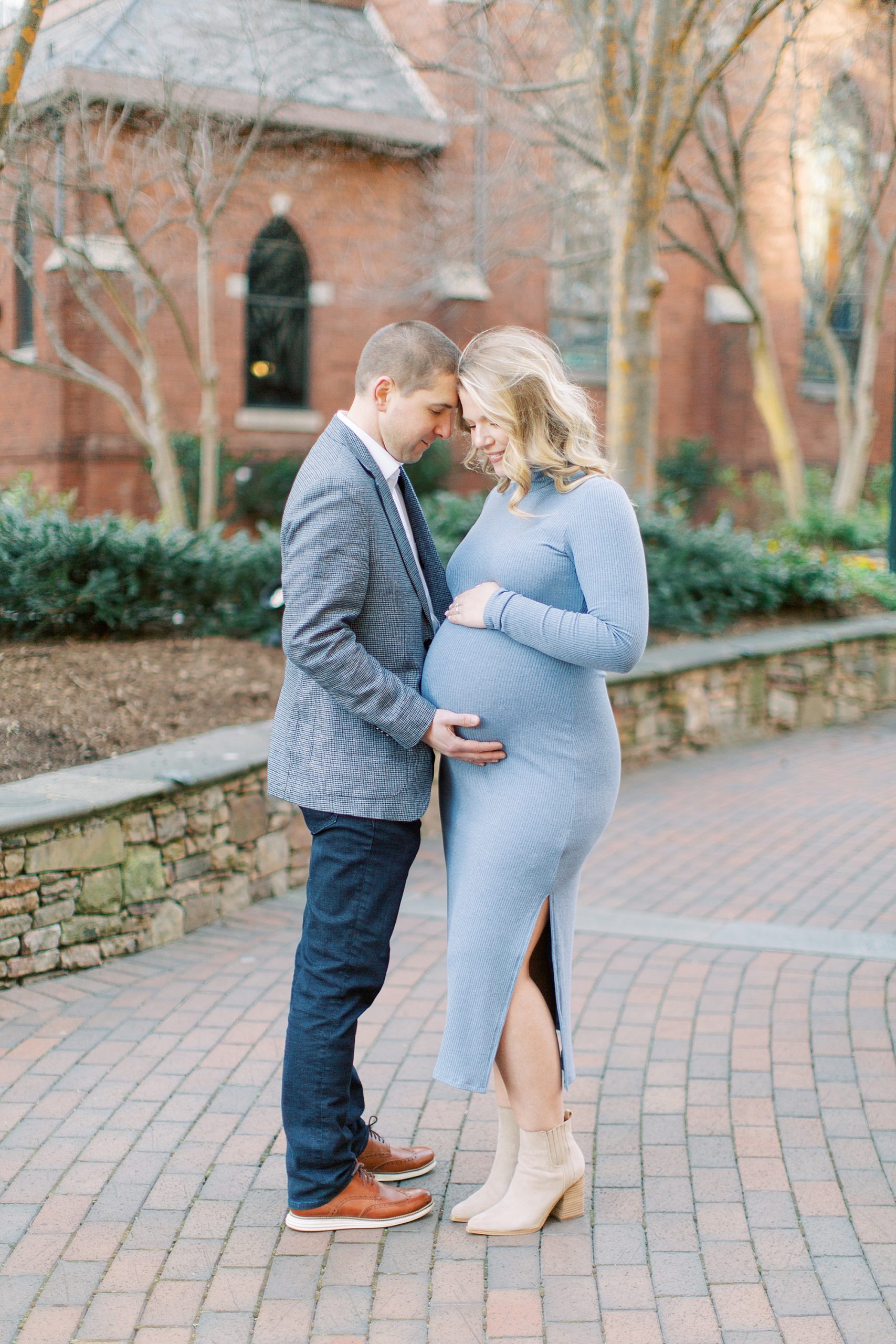 bride and groom smile together during Uptown Charlotte maternity session