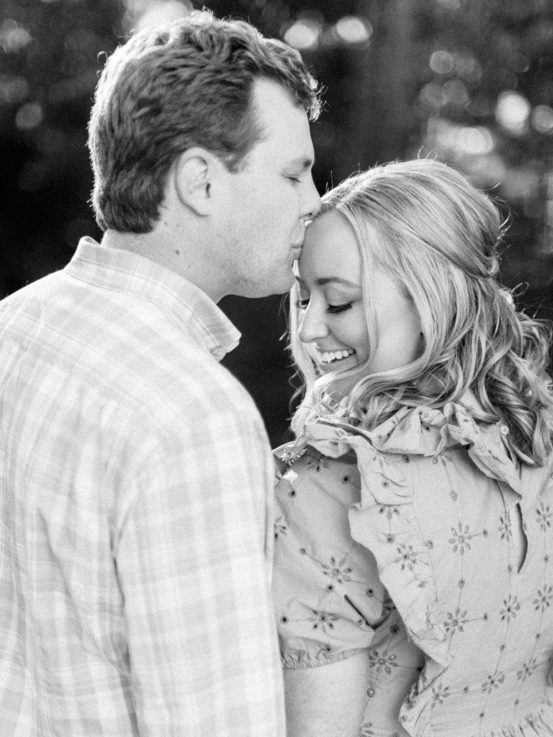 groom kisses bride's forehead during Duke Mansion engagement photos