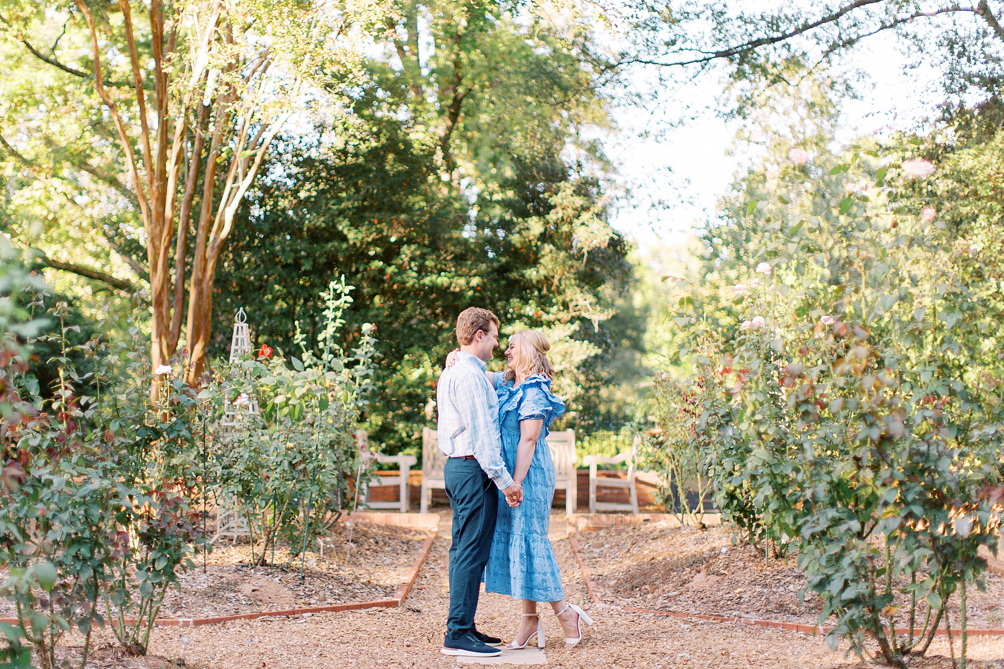 bride and groom stand in gardens together during Duke Mansion engagement photos