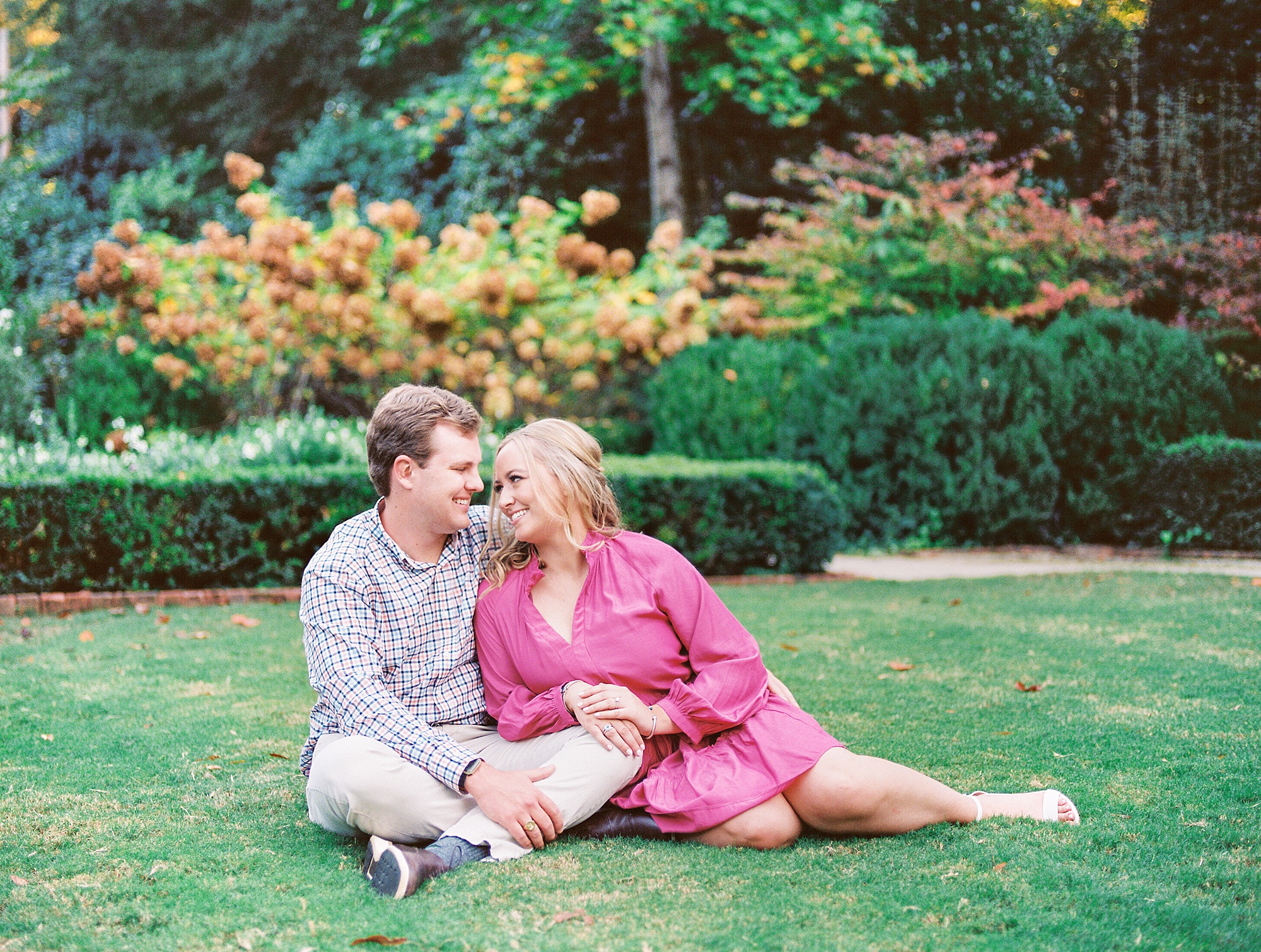 couple sits together on lawn during photos at Duke Mansion