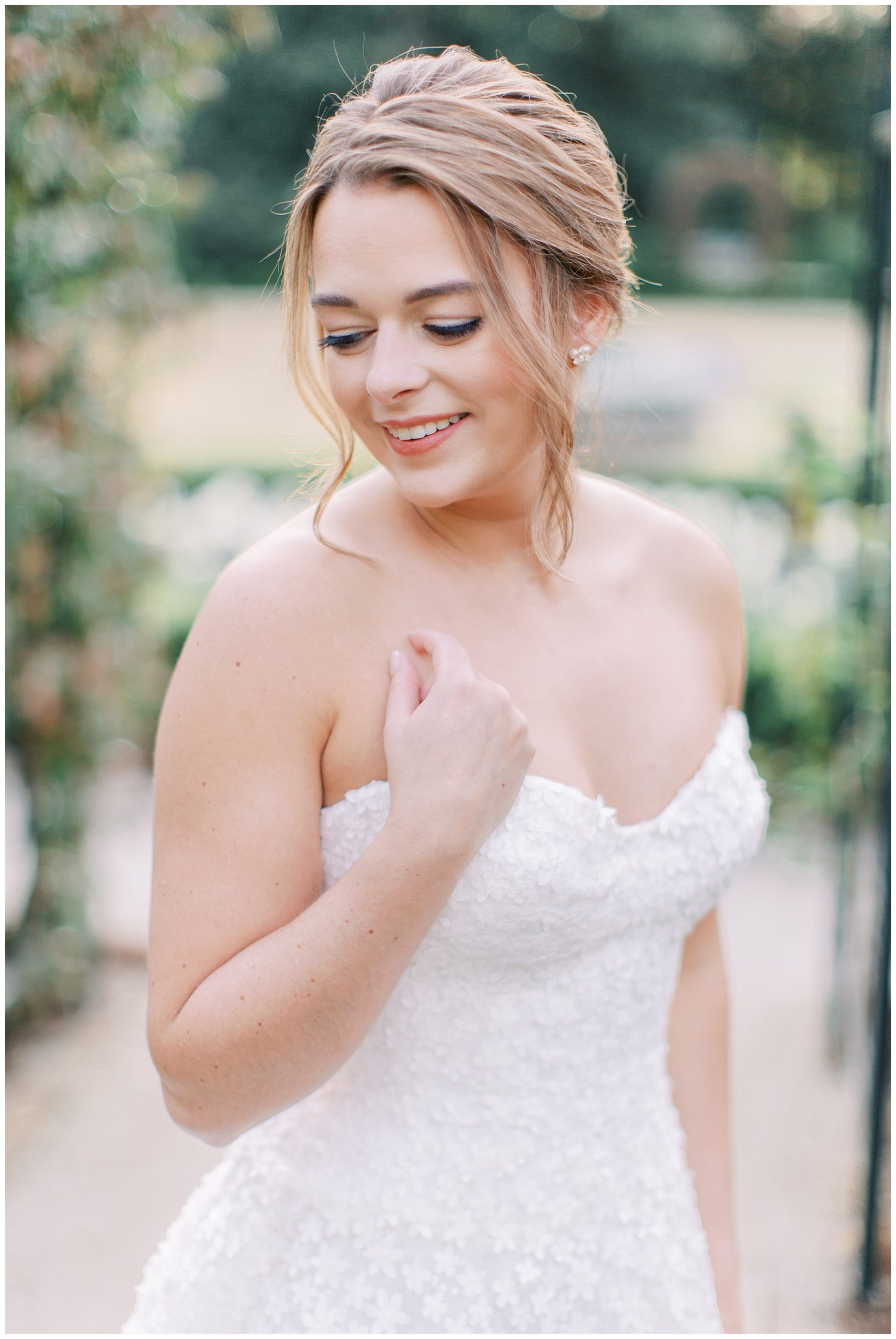 bride places hand on chest looking over shoulder during Duke Mansion bridal portraits