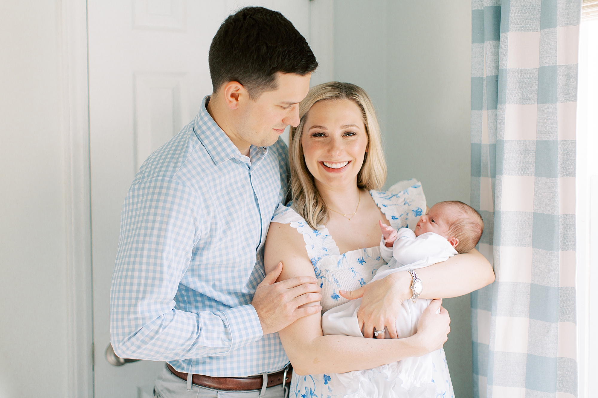new parents hold son in nursery during lifestyle newborn session