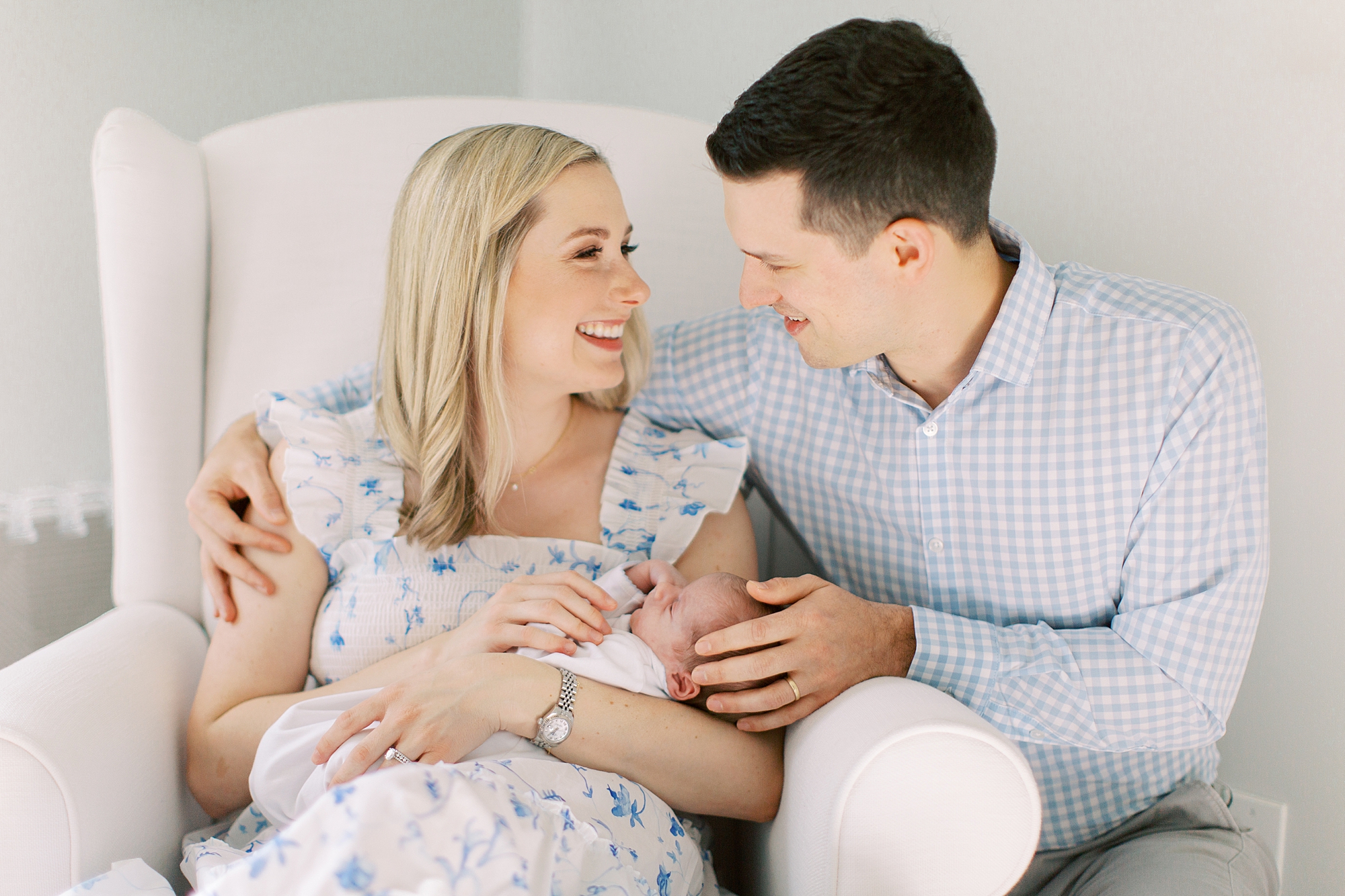 parents smile at each other while holding baby boy