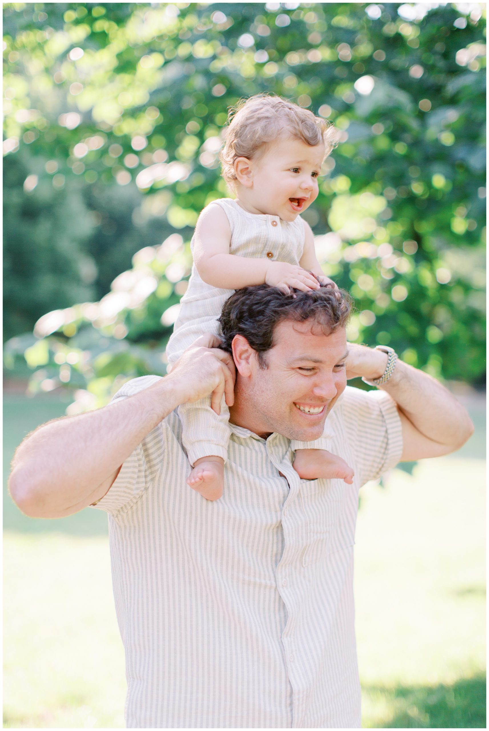dad walks with son on his shoulders during family session in Charlotte NC