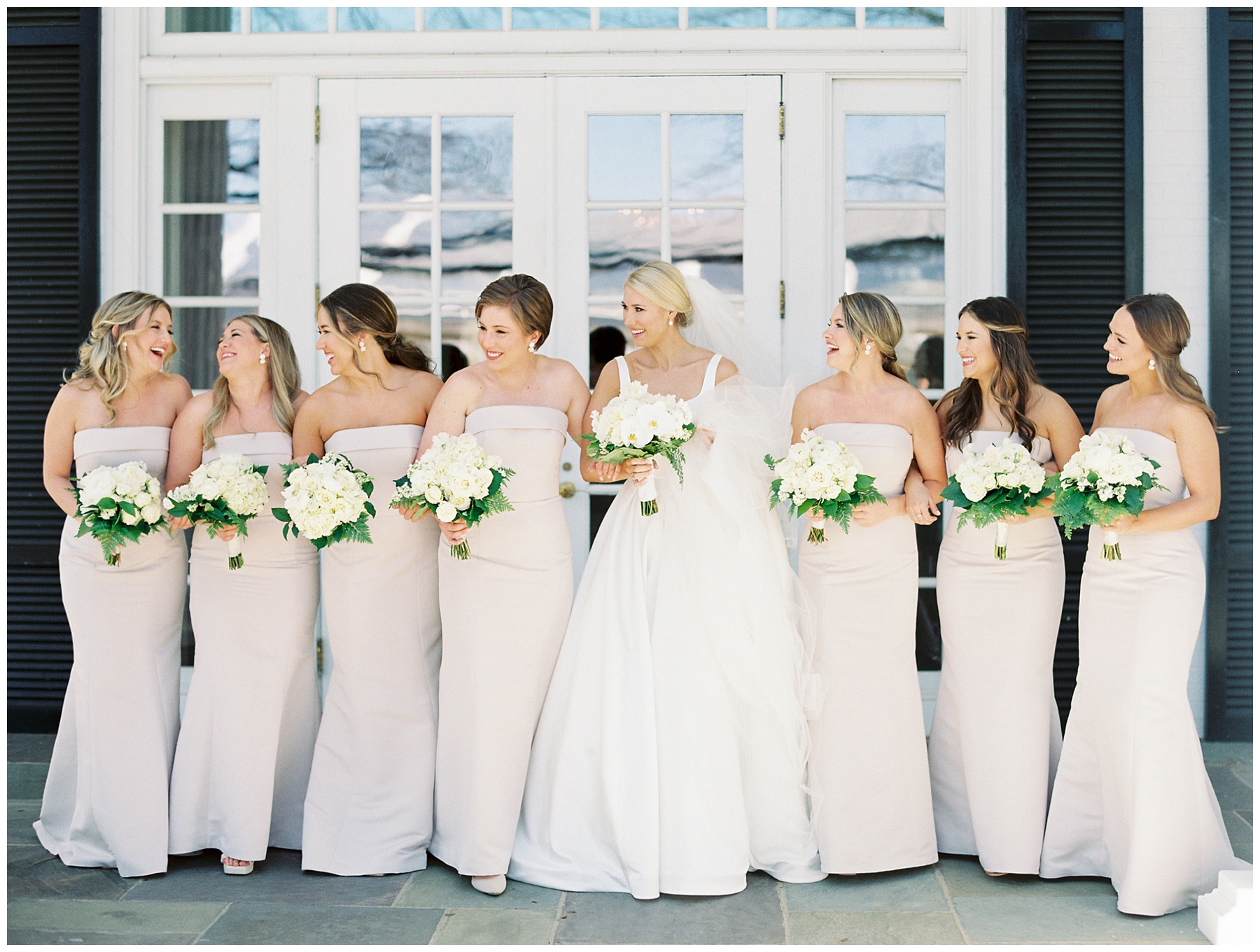 bride and bridesmaid walk together with white bouquets at Quail Hollow Club