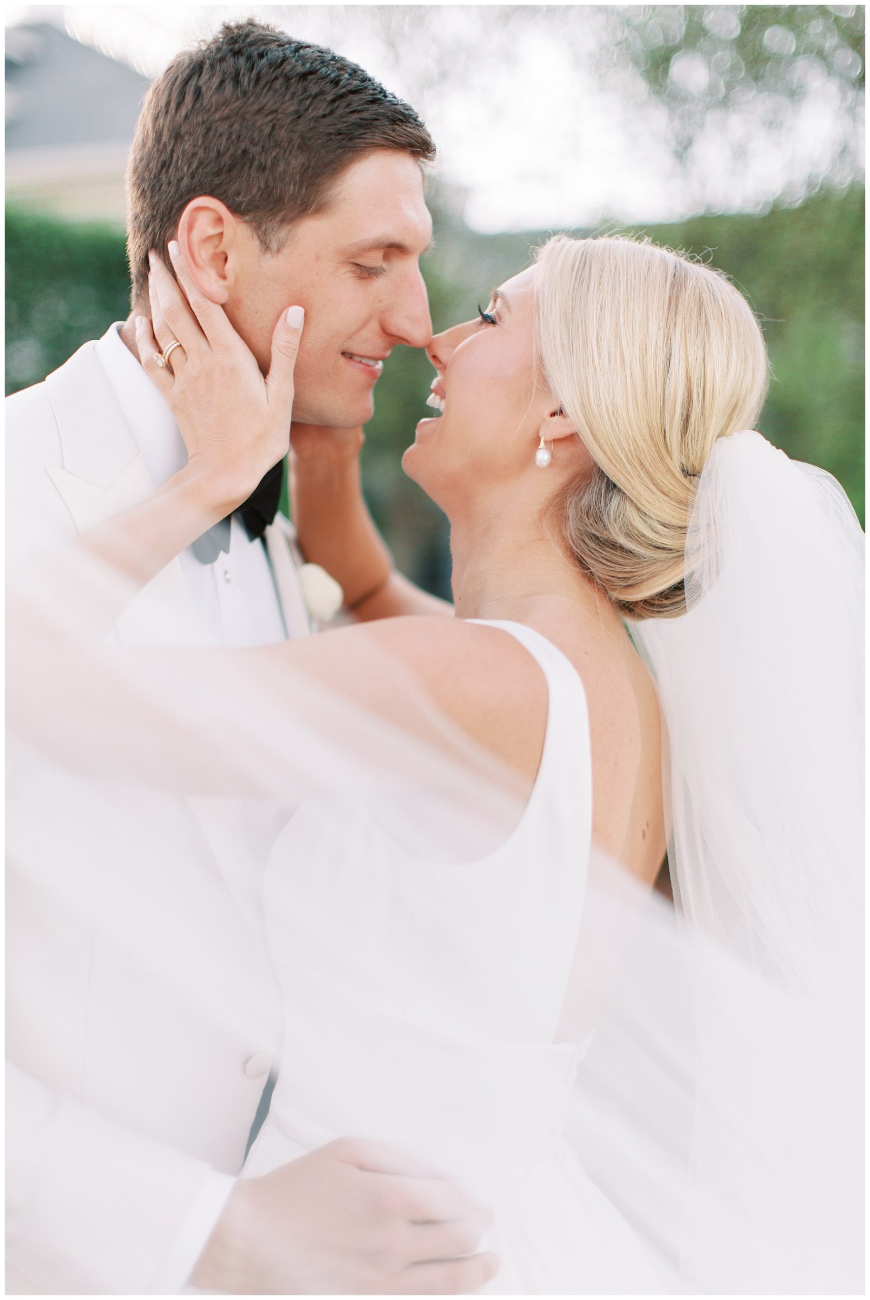bride and groom laugh during portraits touching noses