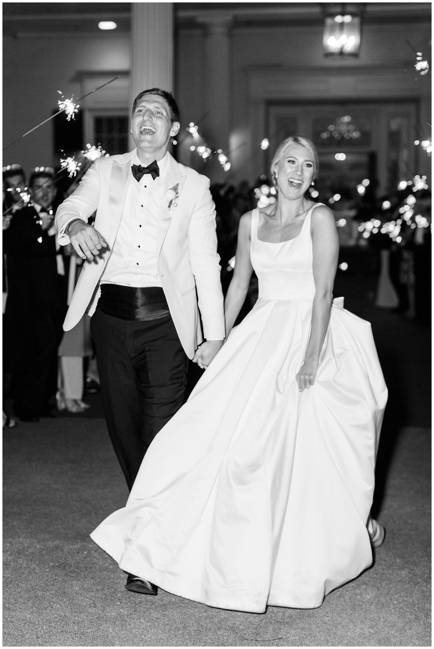 bride and groom laugh holding hands leaving sparkler exit