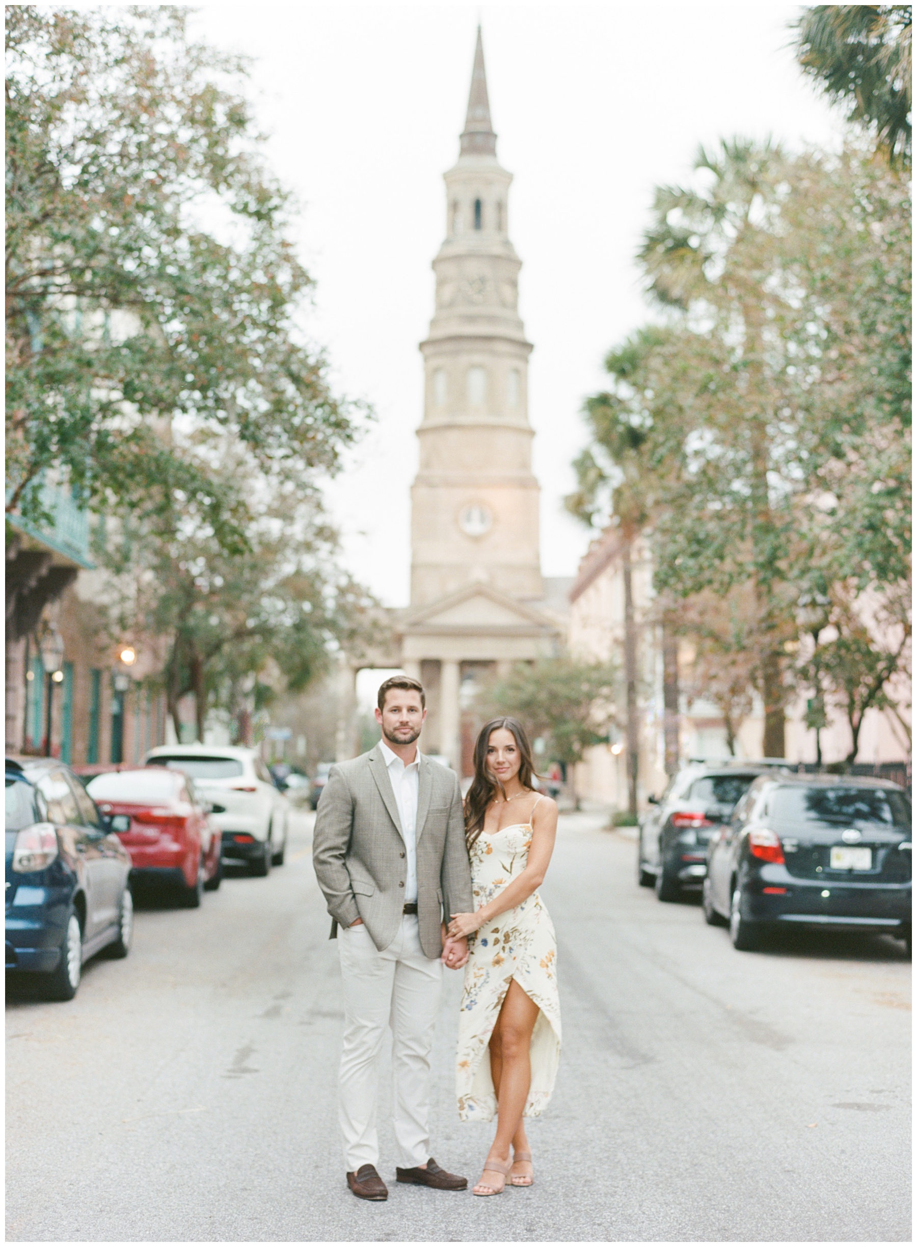 engaged couple walks in front of state building in Charleston SC on street 