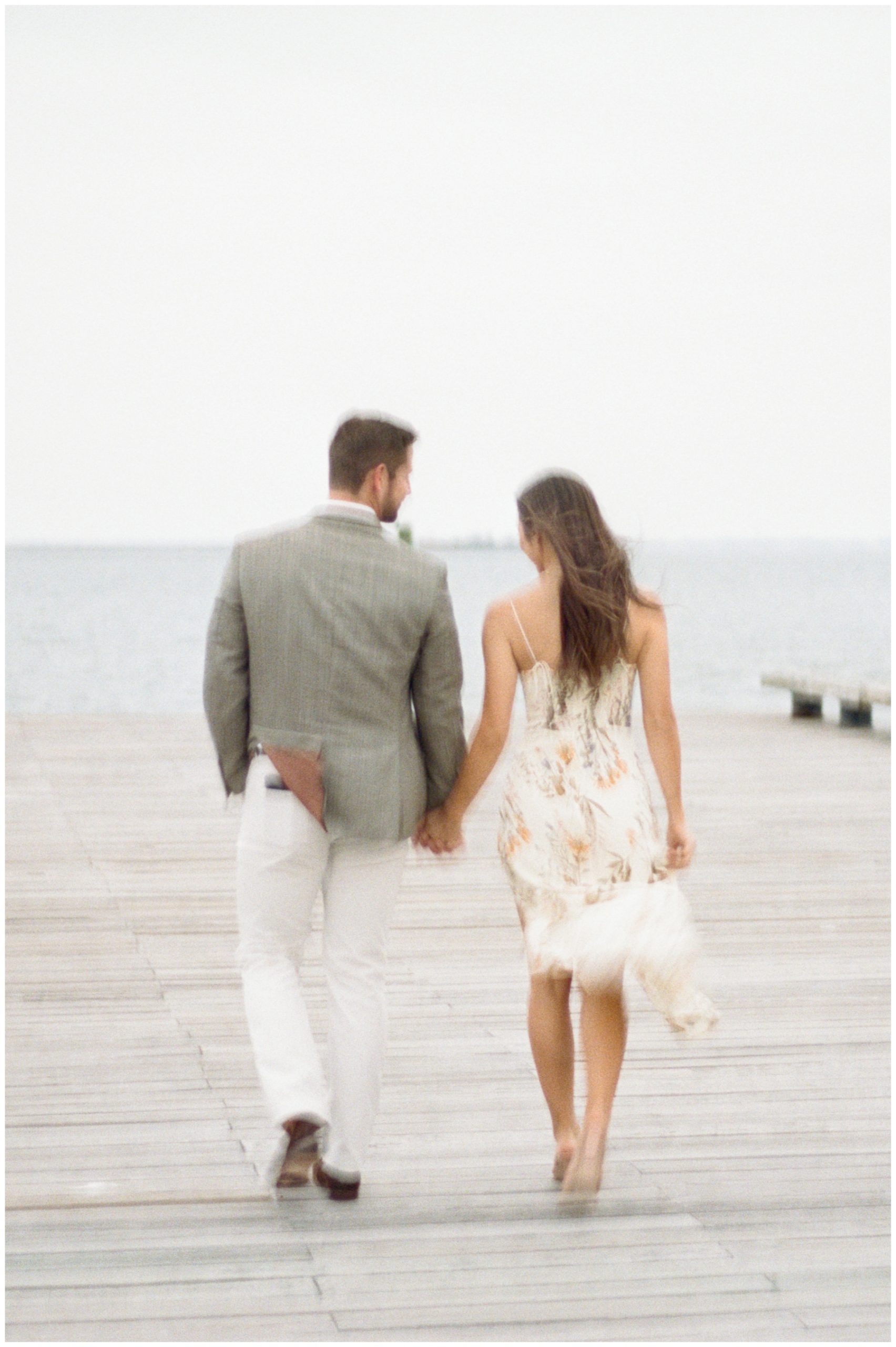 blurry photo of couple holding hands walking on dock in Downtown Charleston