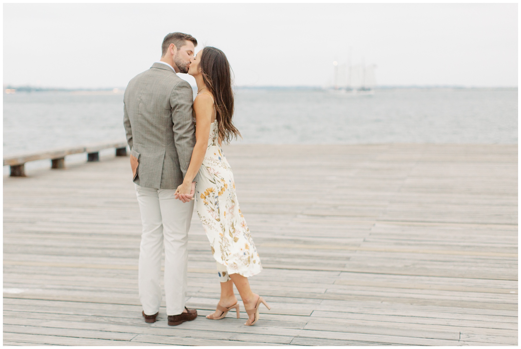 bride and groom kiss on wooden dock in Charleston SC along waterfront 